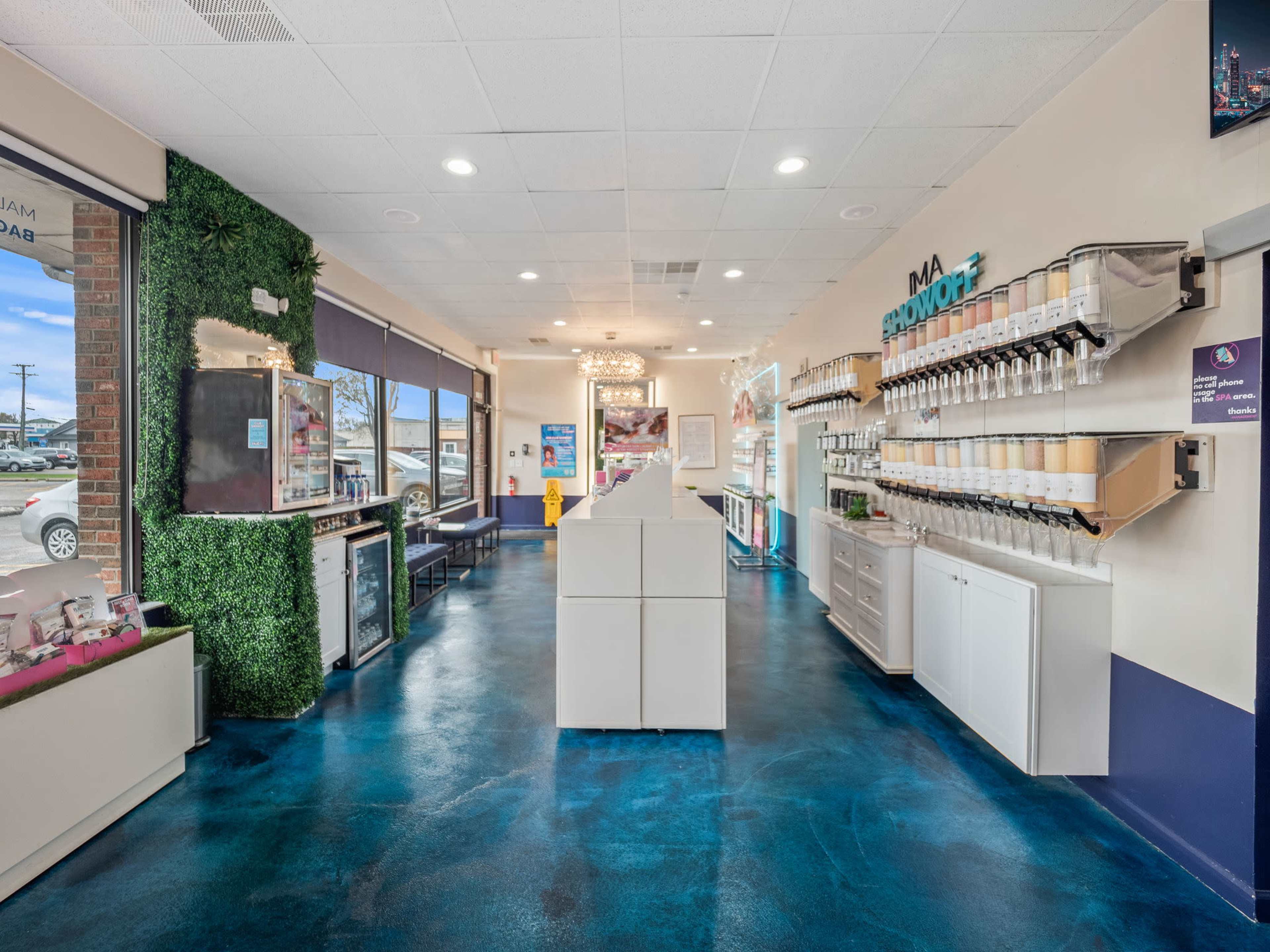 A brightly lit interior of a shop with a modern design featuring beverage dispensing machines on the walls and a clean, polished floor.