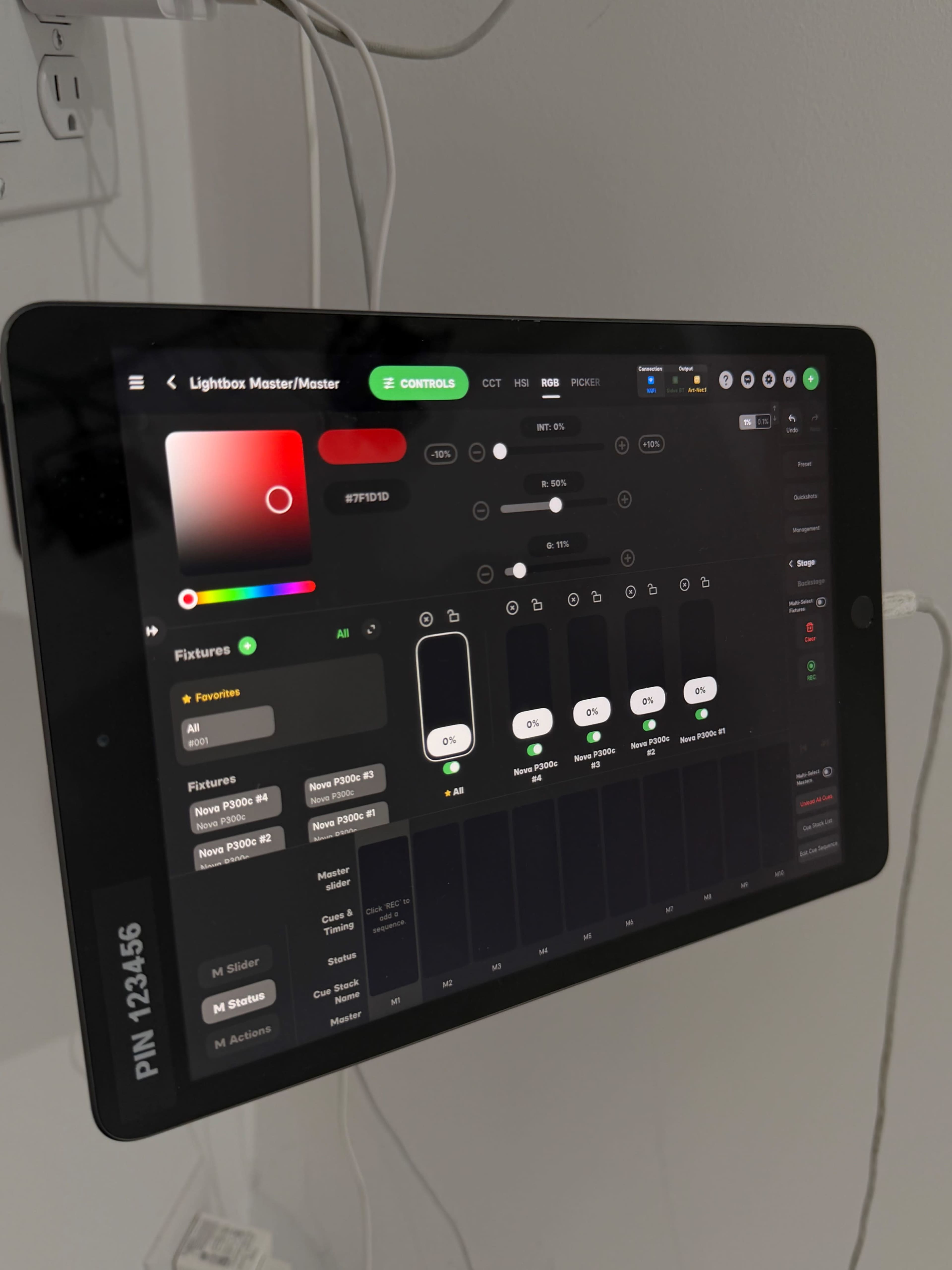 An iPad is mounted on a wall displaying a lighting control interface with various settings and options.