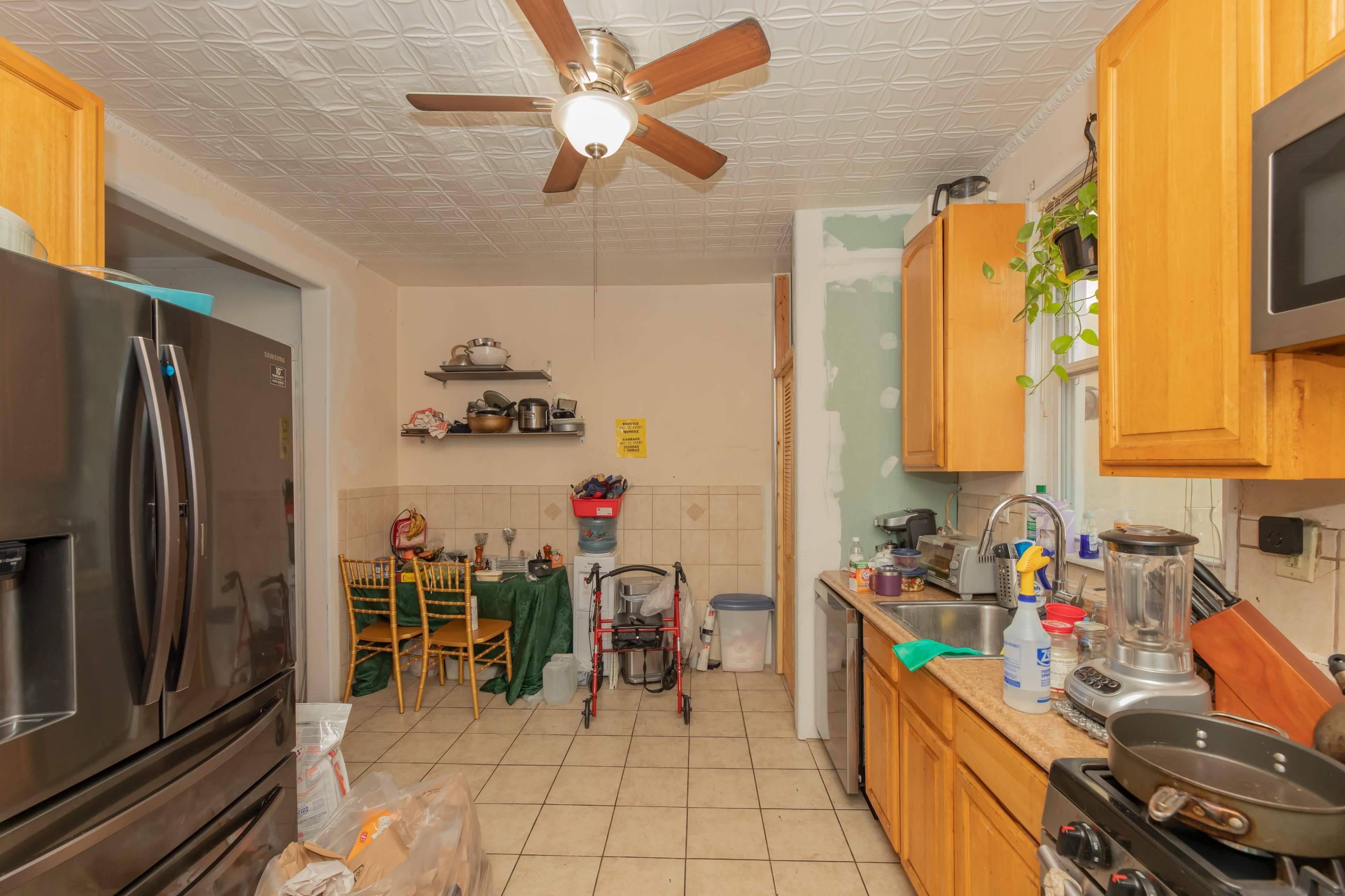 A kitchen with wooden cabinets, a ceiling fan, and a dining area featuring a table and chairs.