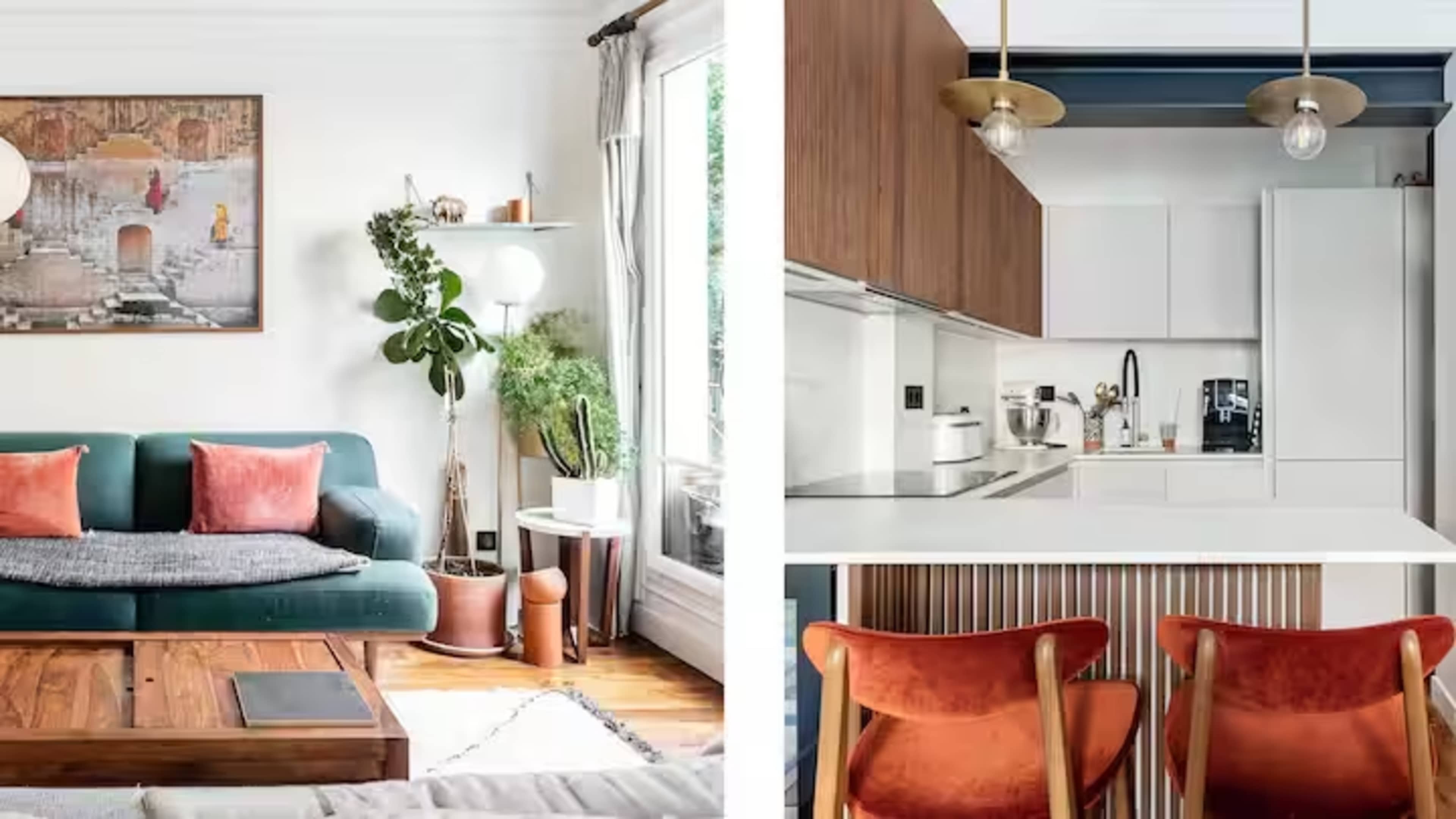 The image shows a cozy living room featuring a green sofa with orange cushions and a kitchen area with modern cabinetry and two red chairs at a white counter.