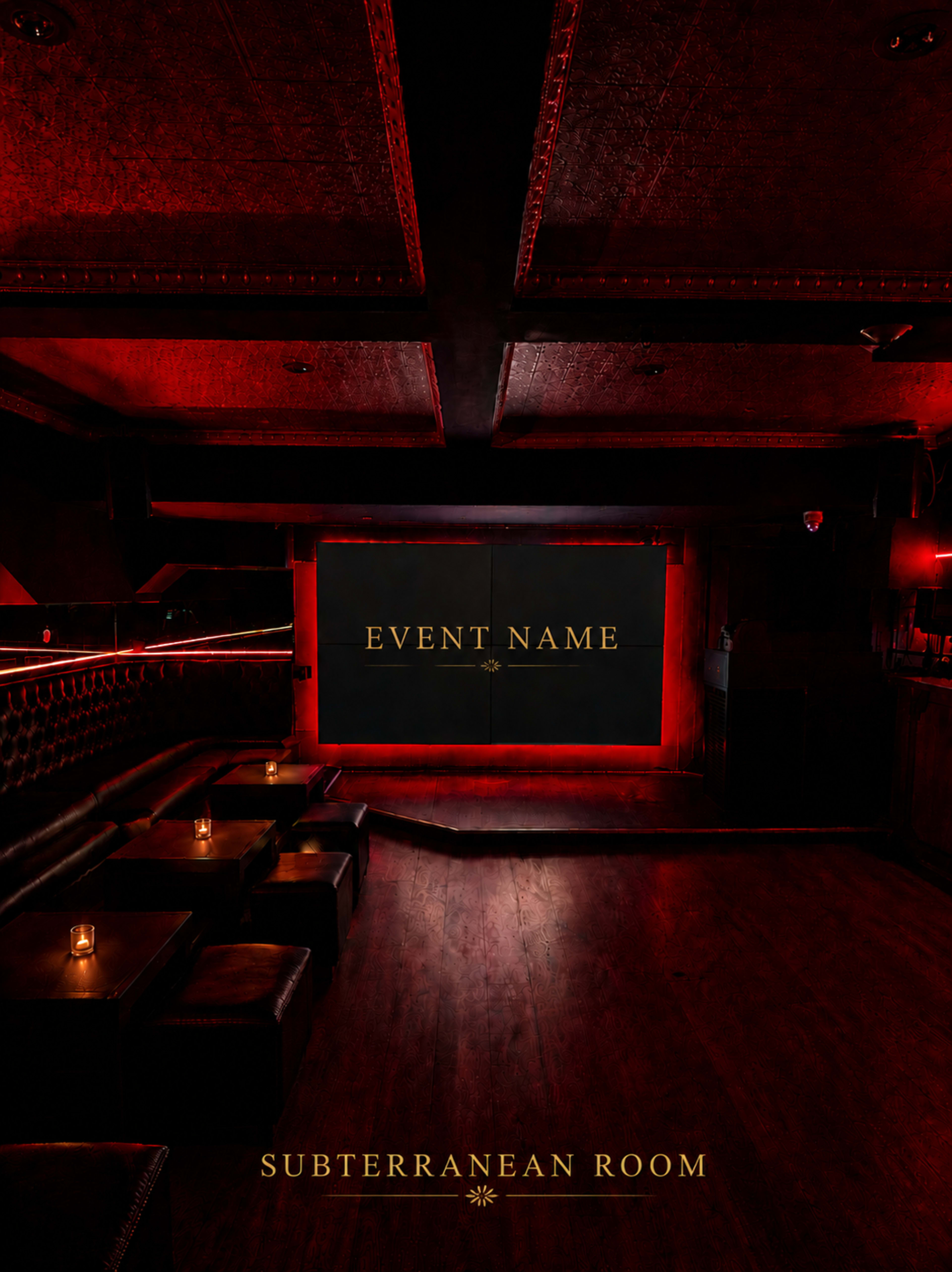 The image shows a dimly lit lounge area with dark wood flooring, low seating arrangements, and a large screen set against a red wall.