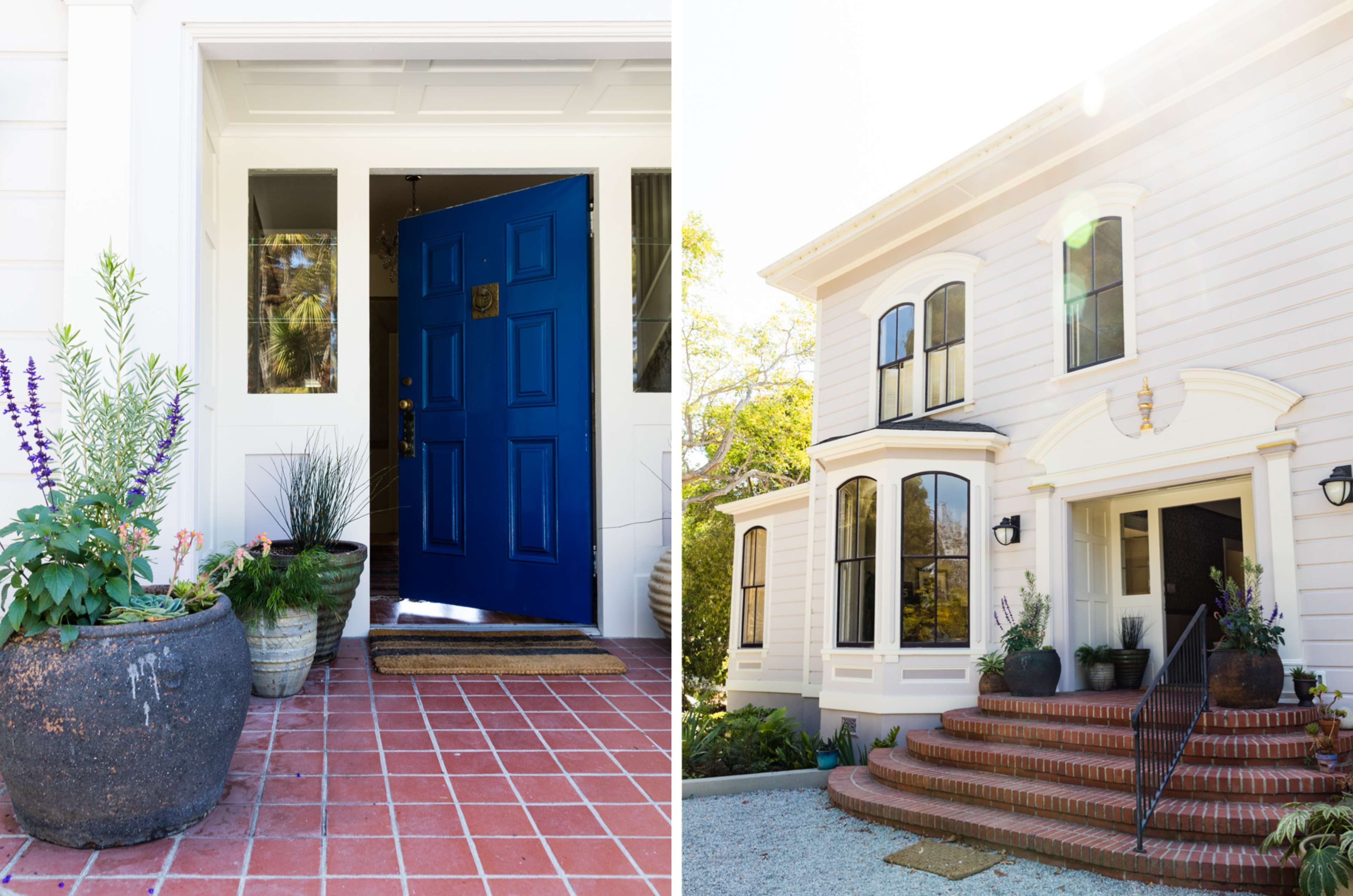 The image shows a bright blue front door leading into a home, accompanied by potted plants on a brick pathway, with a view of a large, two-story house that features multiple windows and a staircase.