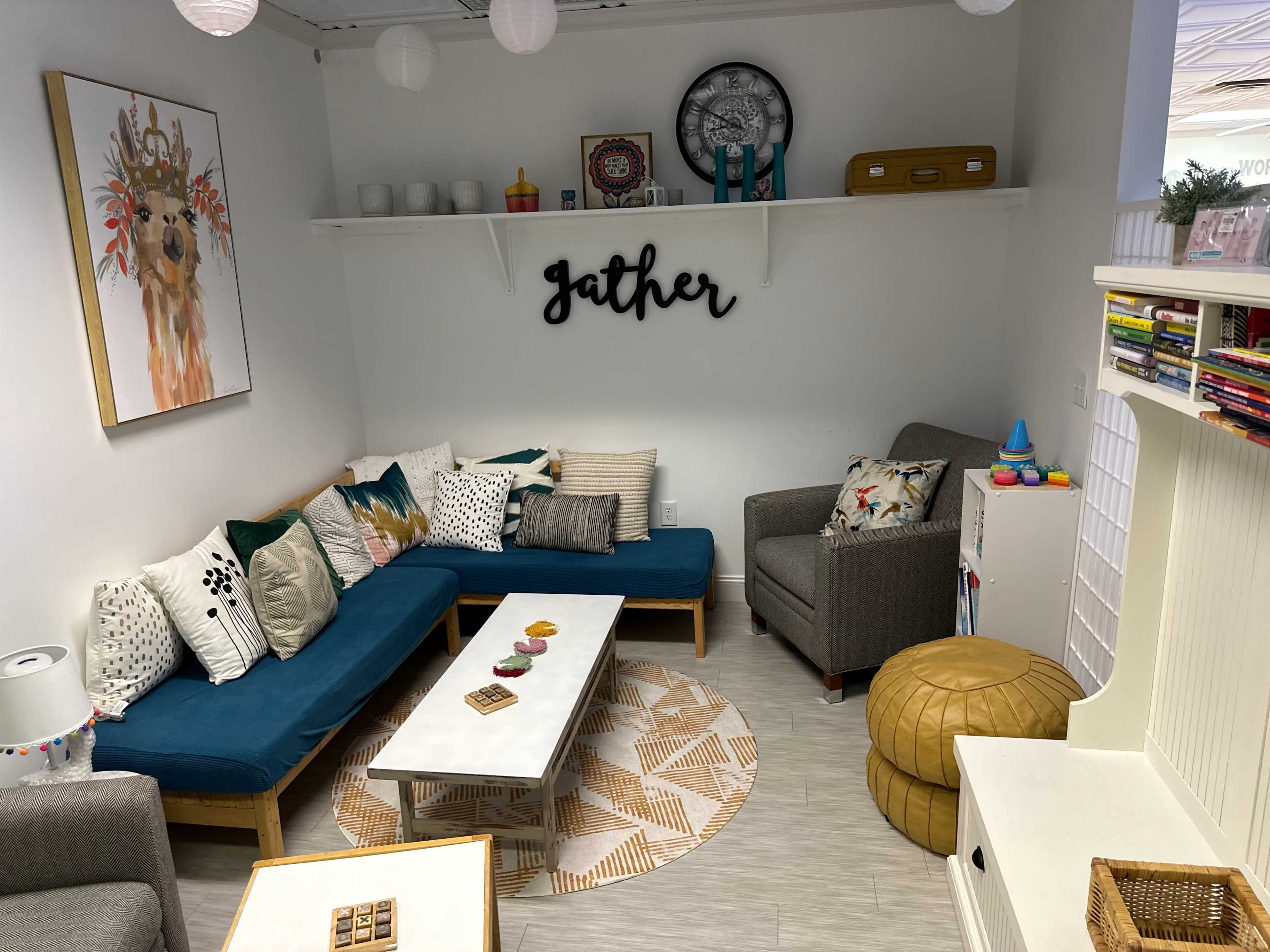 A cozy seating area features two sofas, a coffee table, and decorative elements against a light-colored wall.