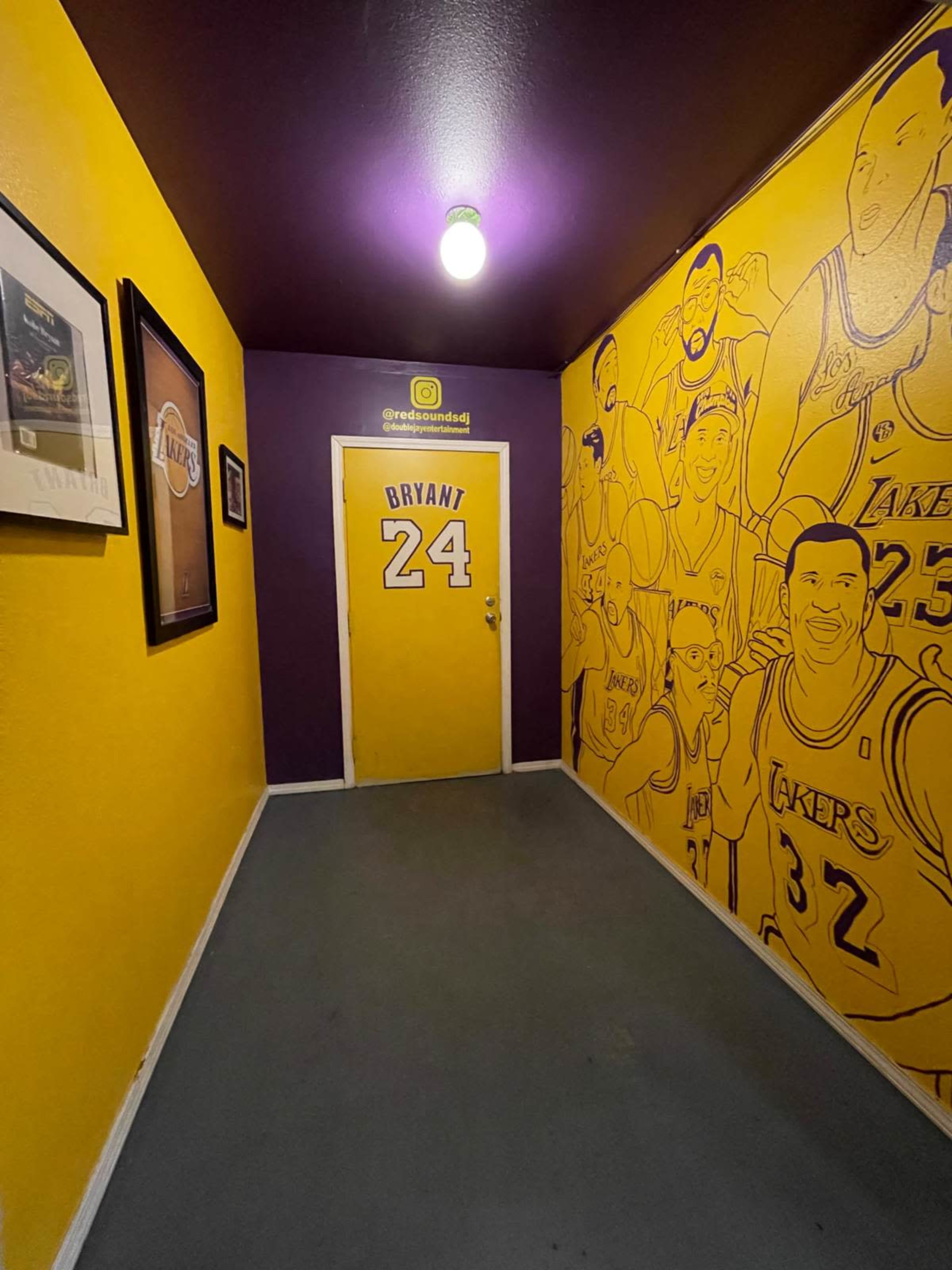 The image shows a narrow hallway painted in yellow and purple, with a door labeled "BRYANT 24" and walls adorned with illustrations of basketball players.