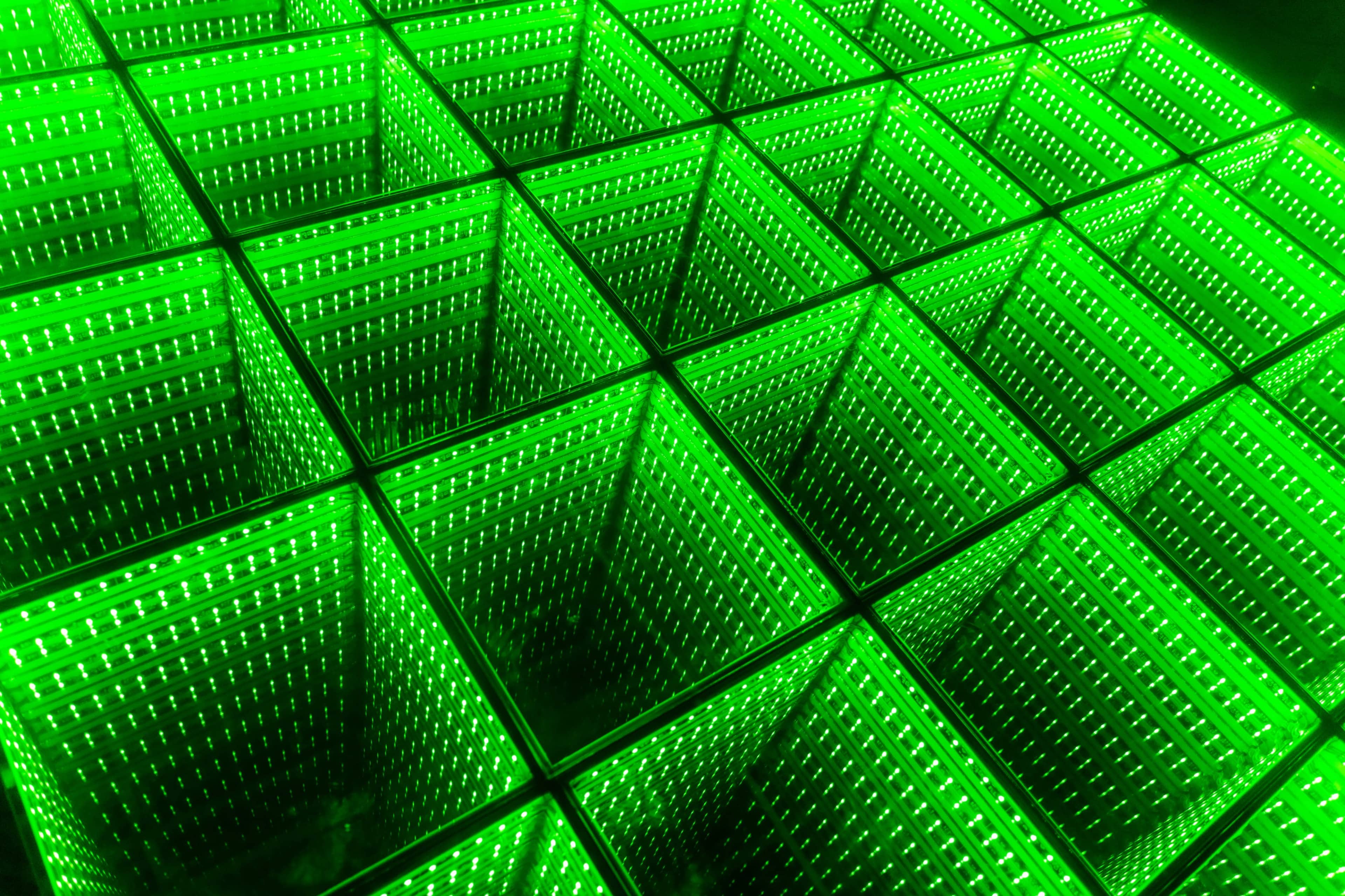 A grid of illuminated green containers arranged in a repetitive pattern.