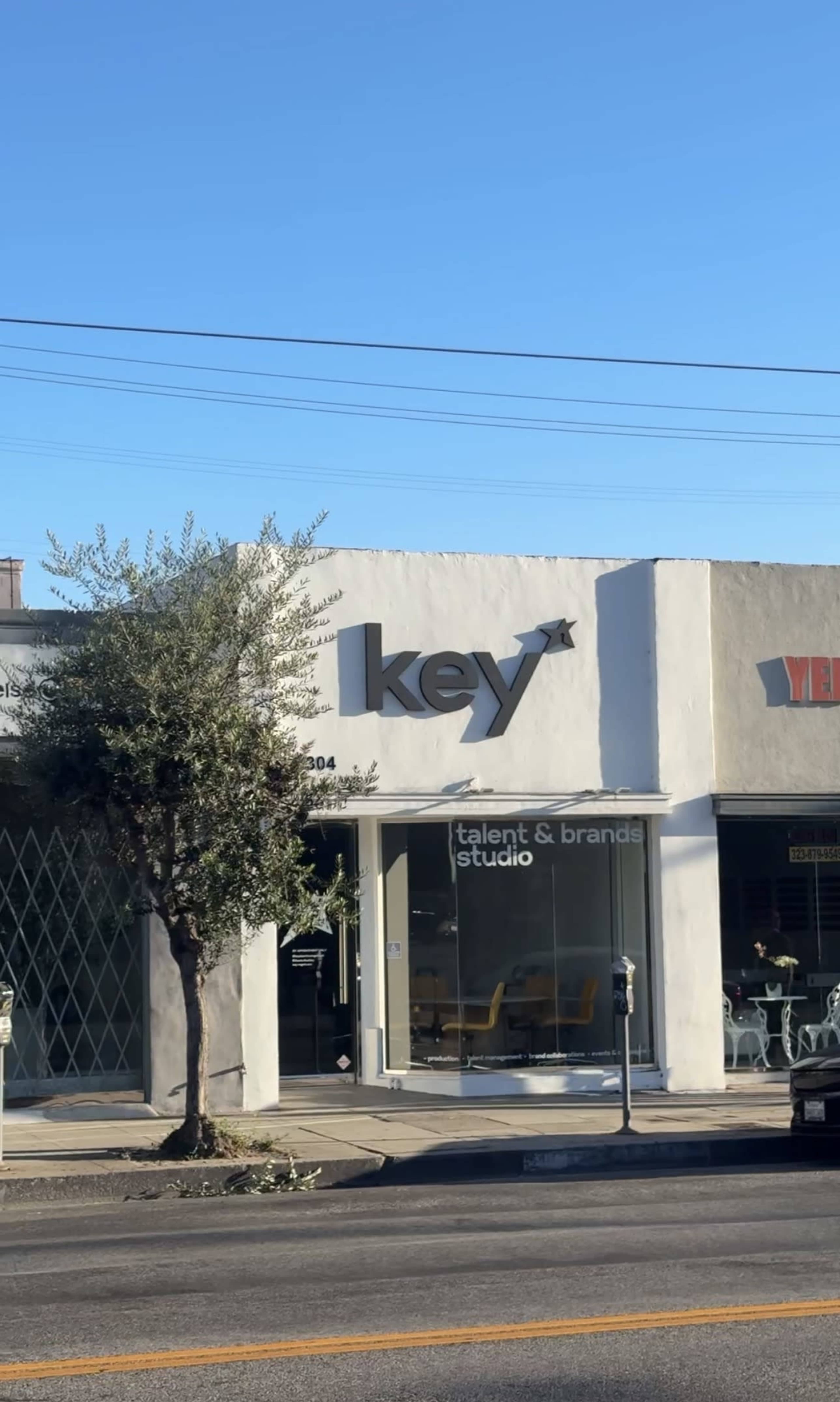 The image shows a building with the sign "key talent & brands studio" on the front, adjacent to another business with a sign that reads "VER."