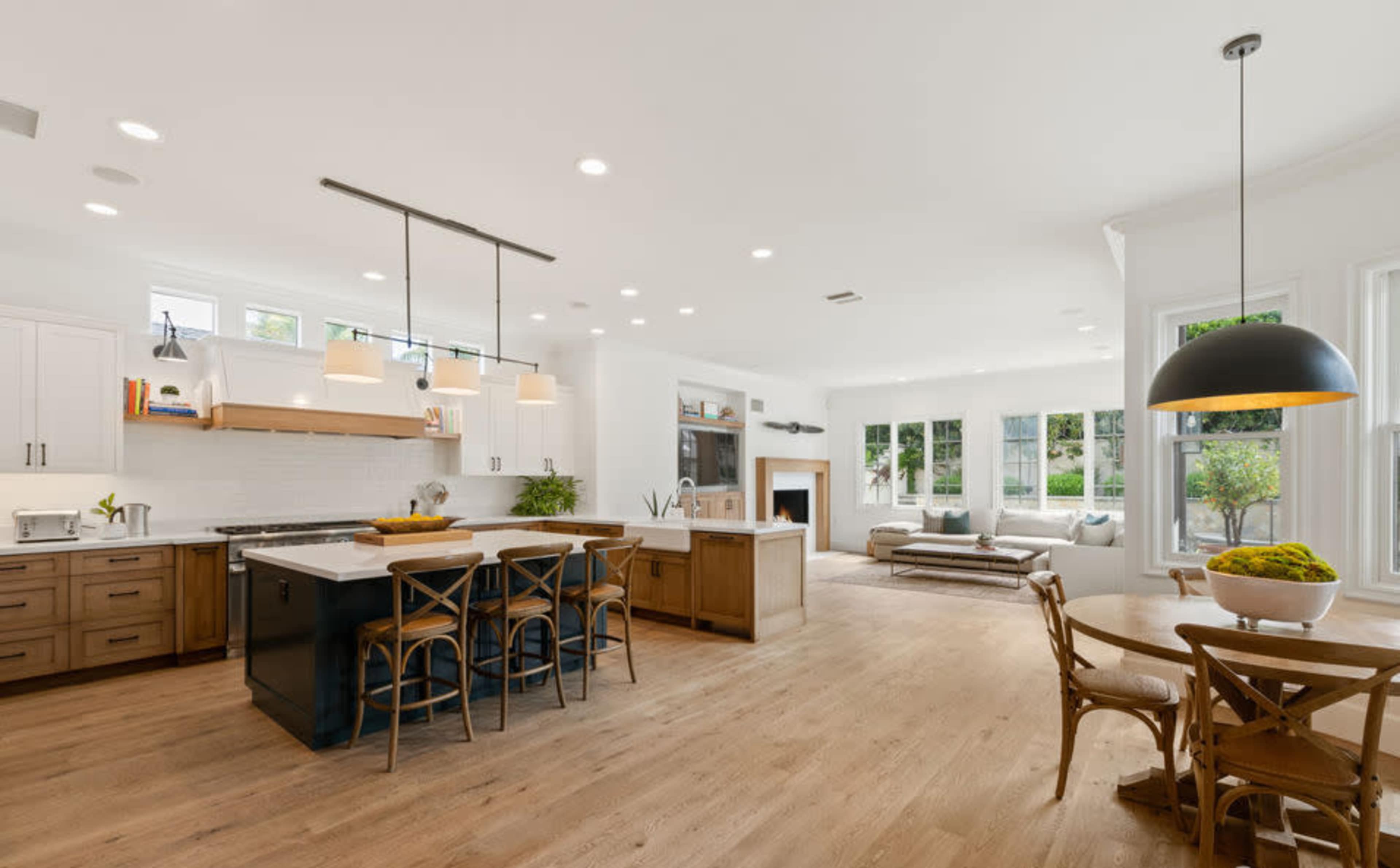 A modern kitchen with a large island and seating, adjacent to a cozy living area filled with natural light.