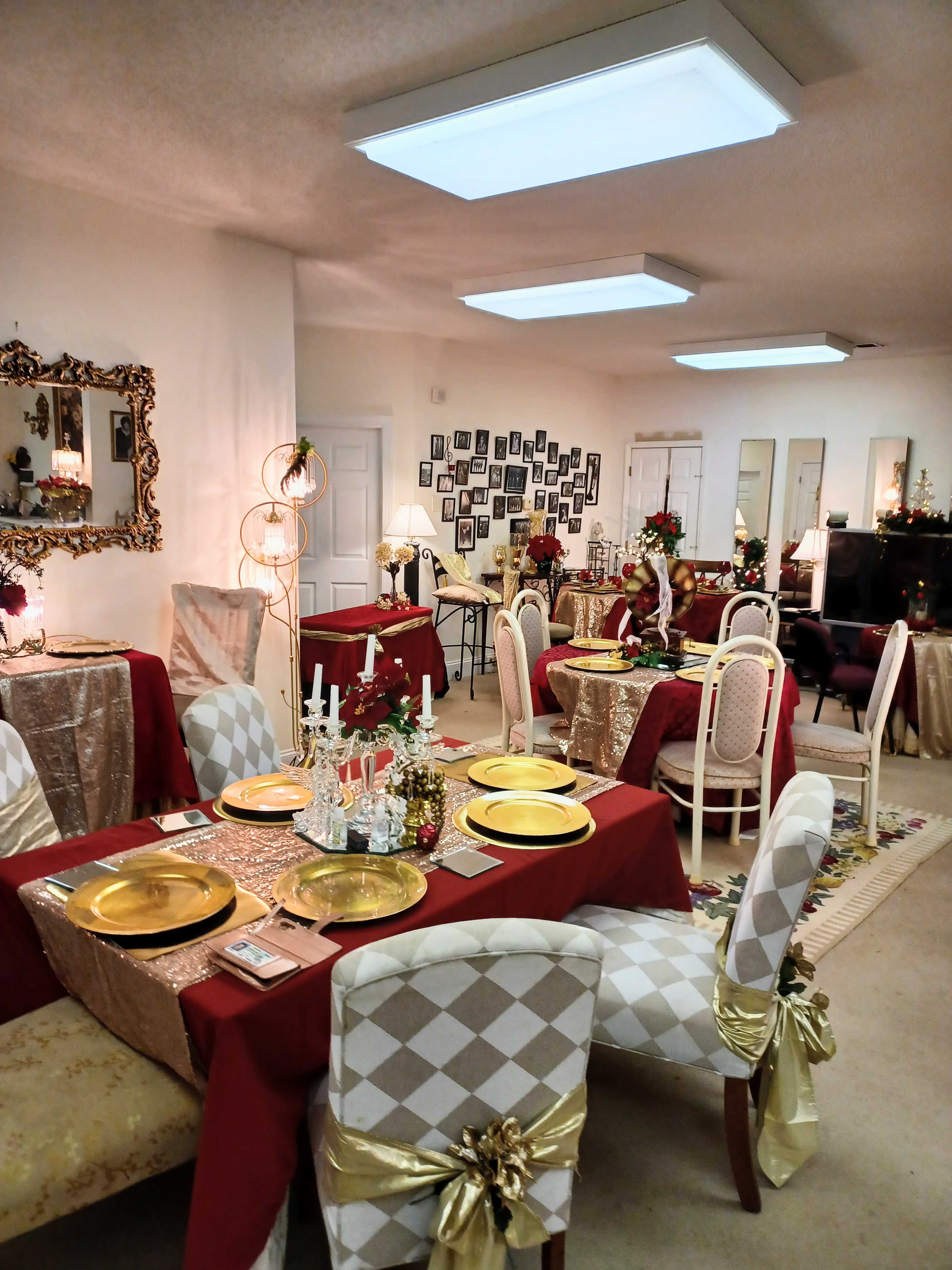 The scene depicts a dining area set with elegantly arranged tables, each adorned with red and gold tablecloths, ornate place settings, and decorative centerpieces.