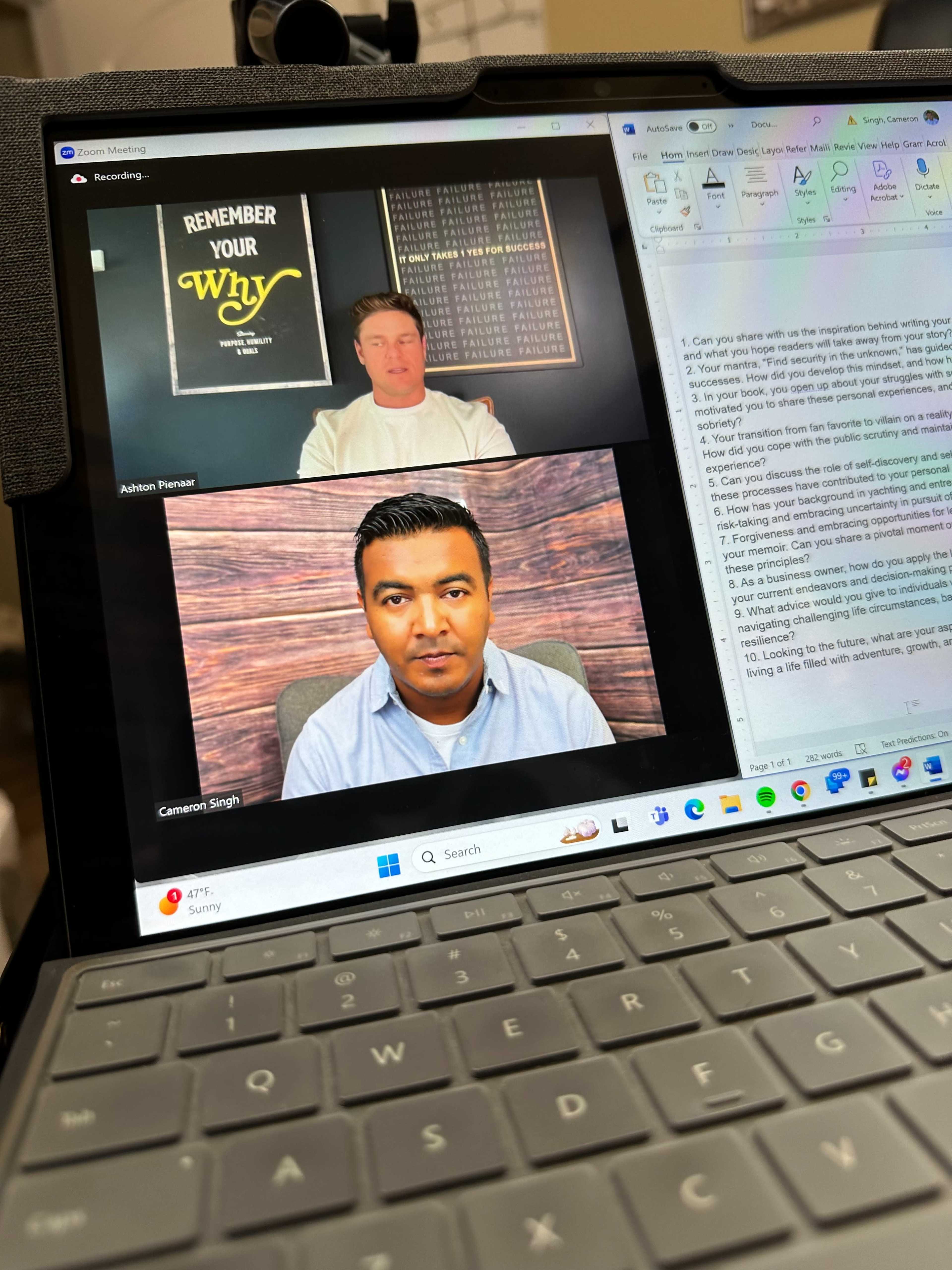 A Zoom meeting in progress with two speakers, Ashton Parner and Cameron Singh, displayed on a tablet screen, while notes and a presentation are visible in the background.