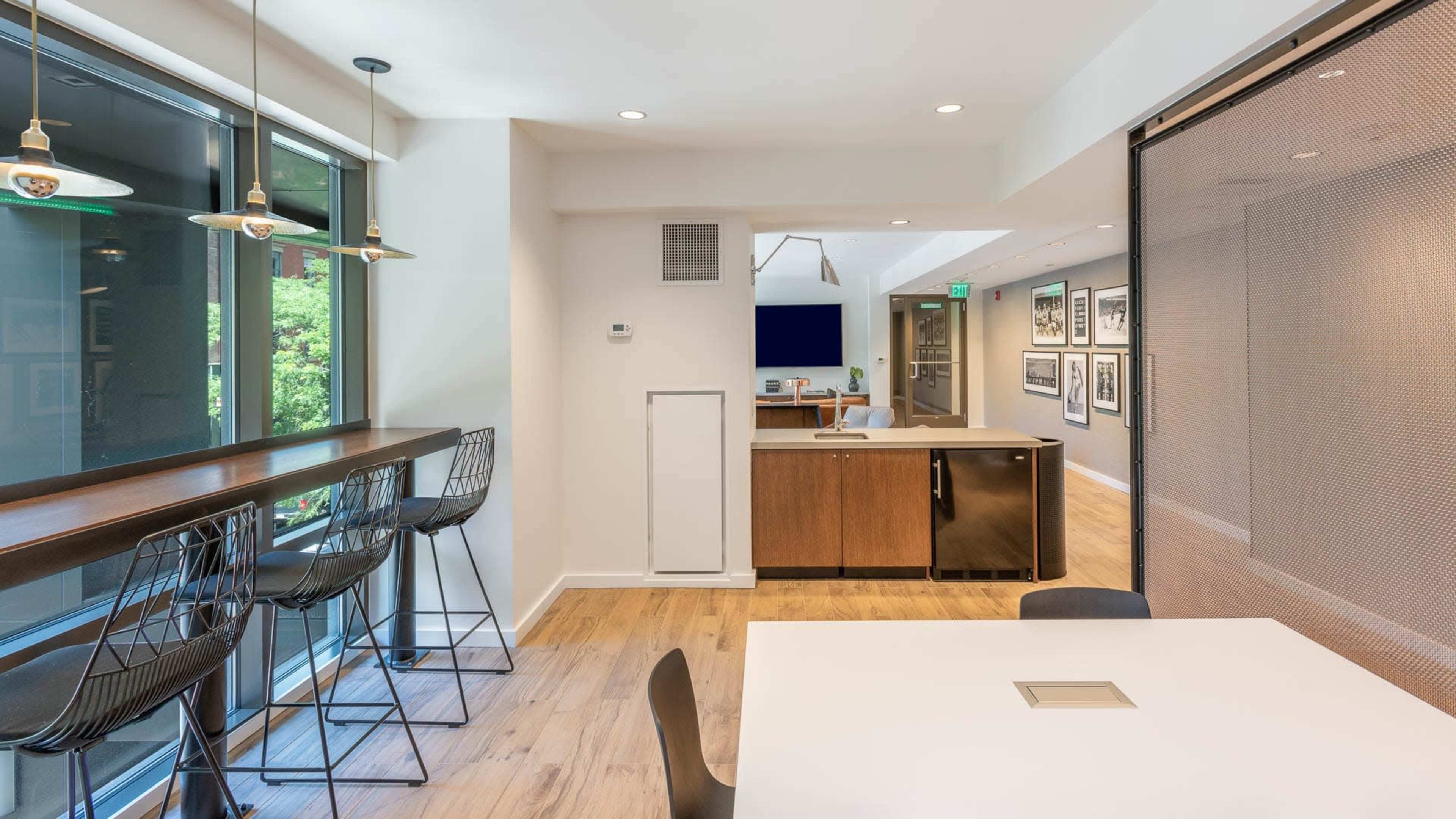 A modern open-concept kitchen and dining area with a bar seating along one wall and a table at the center.