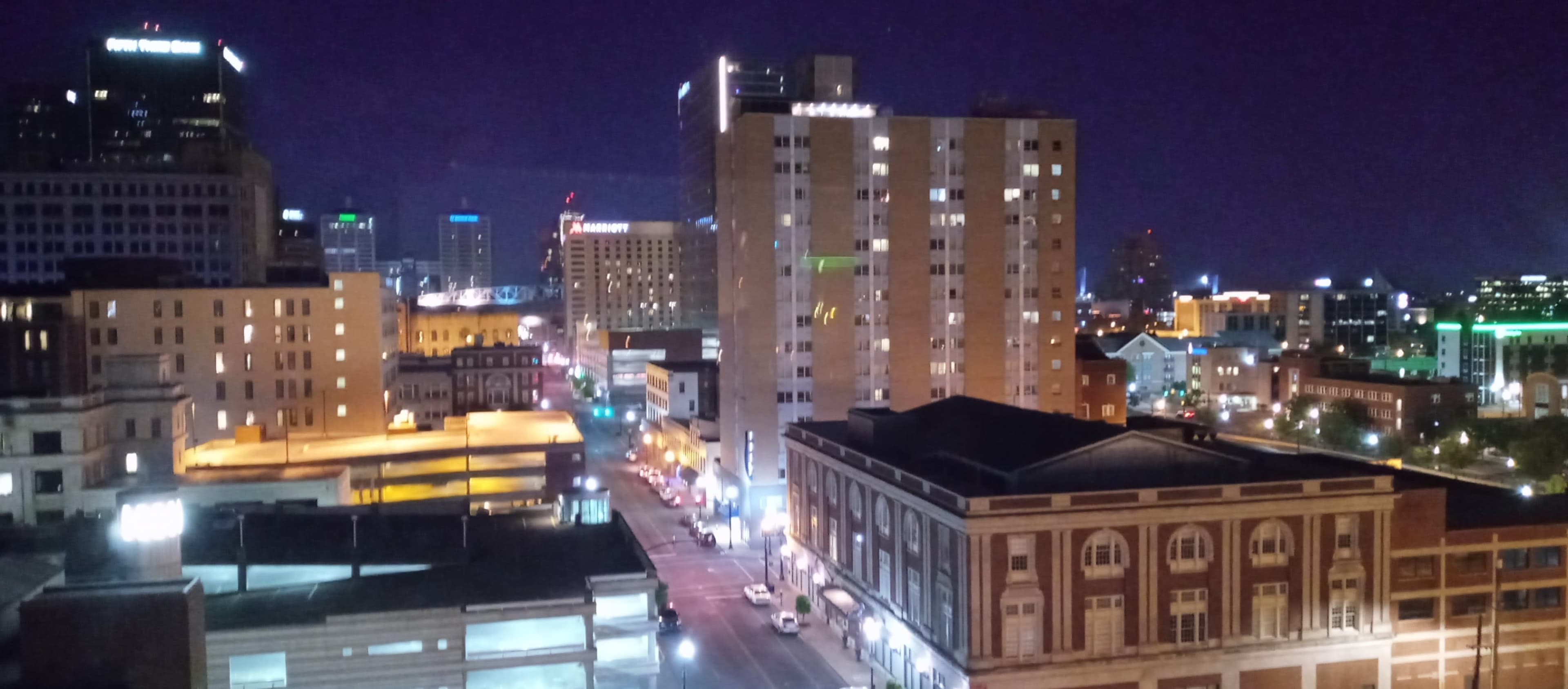 A city skyline at night with illuminated buildings and streets.