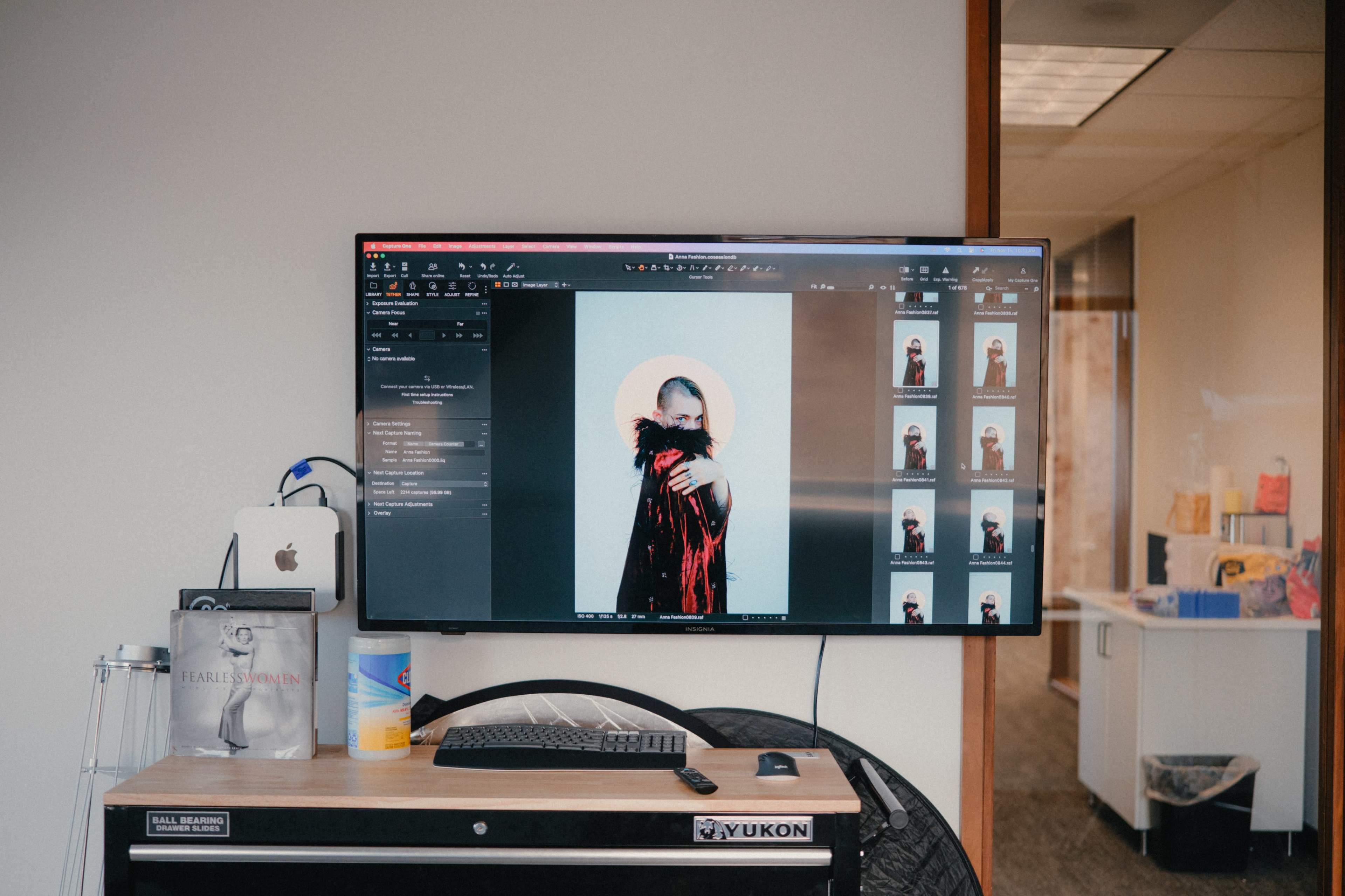 A large monitor displays an image of a person wrapped in fabric, accompanied by several thumbnail images on the side.