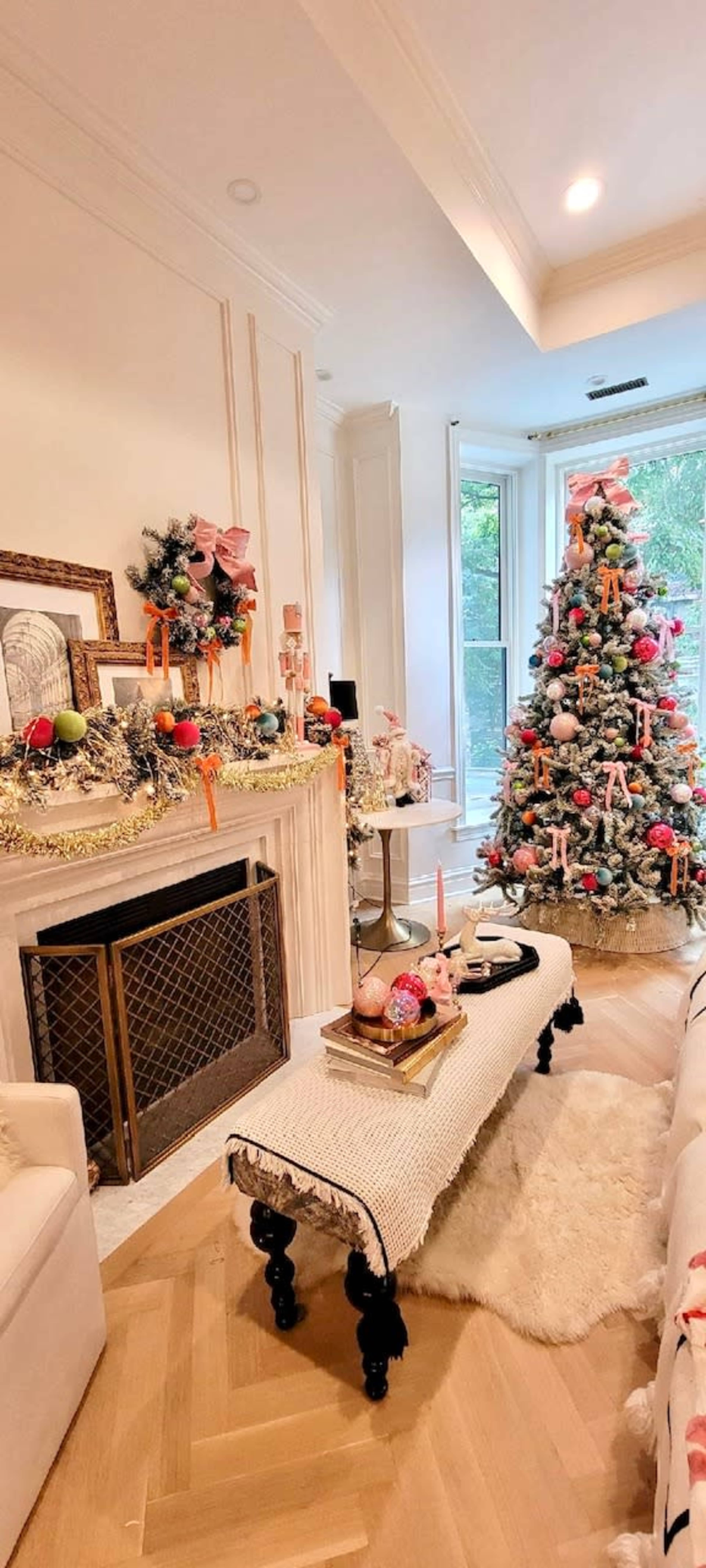 The room features a decorated Christmas tree near a stylish fireplace, with festive ornaments and a cozy seating arrangement.