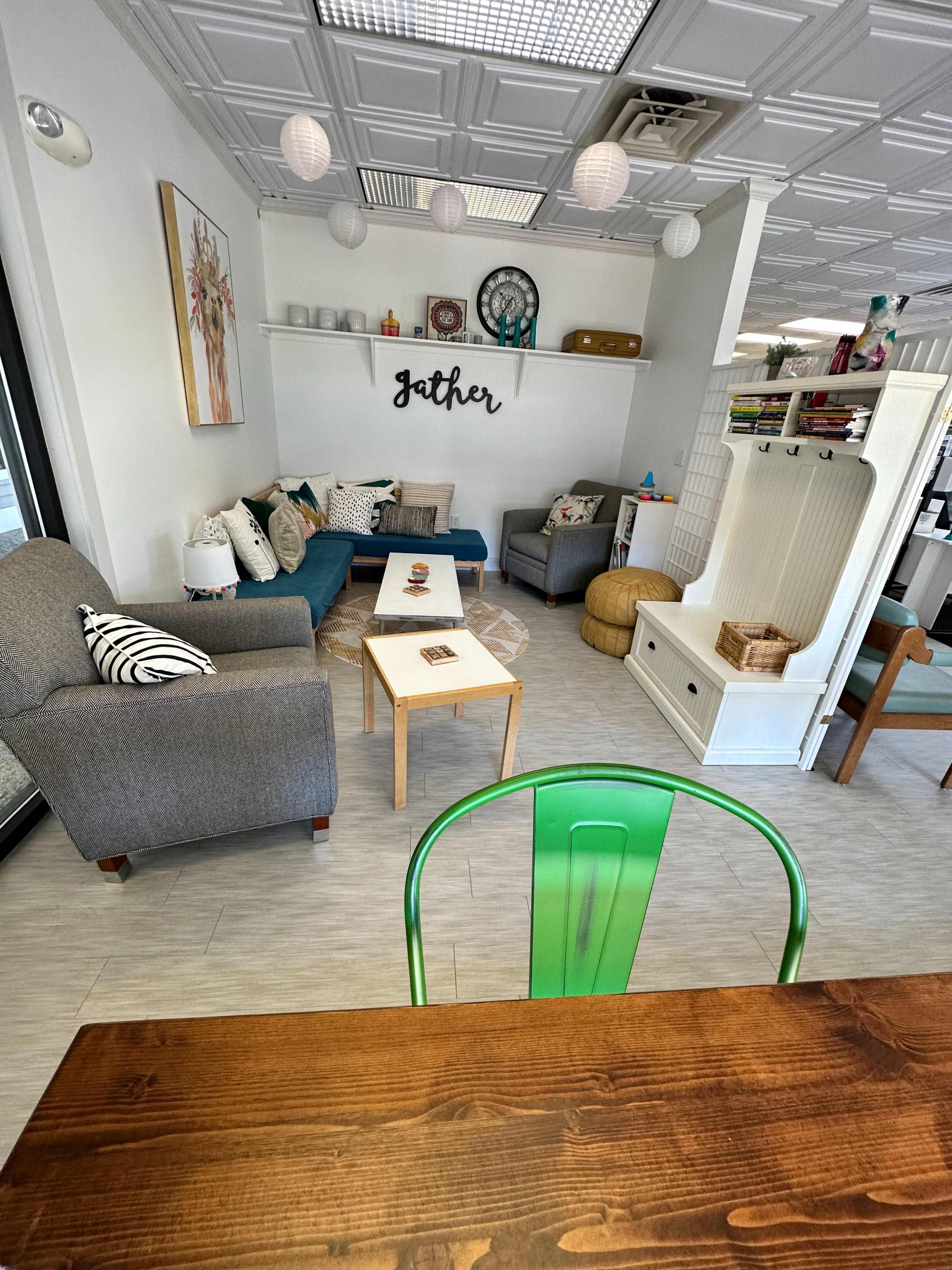 A cozy interior with a seating area that includes sofas, a coffee table, and decorative elements on the walls.
