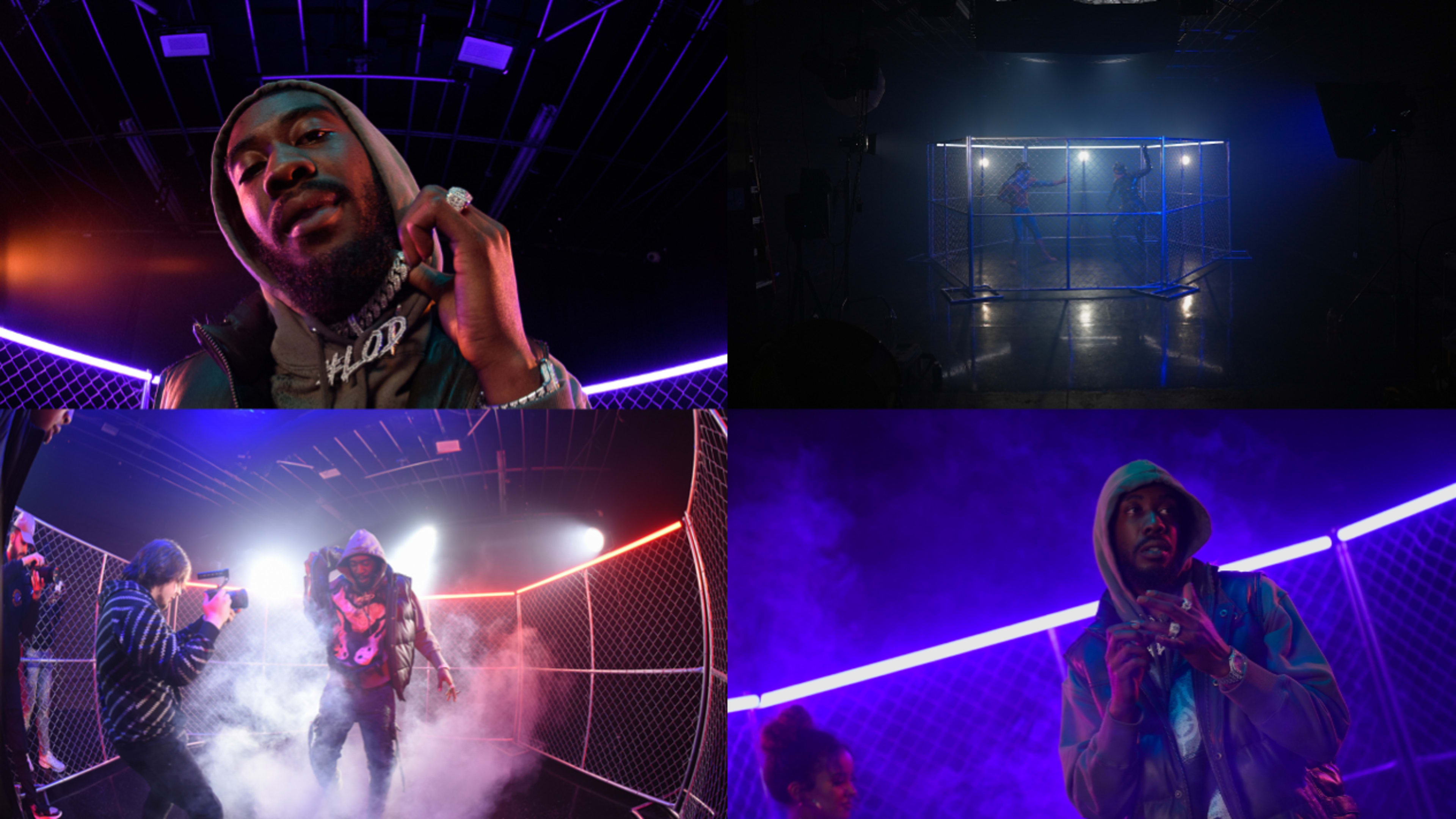 A hip-hop artist performing in a darkened studio, surrounded by colorful lights and a mesh cage structure, with smoke and dancers in the background.