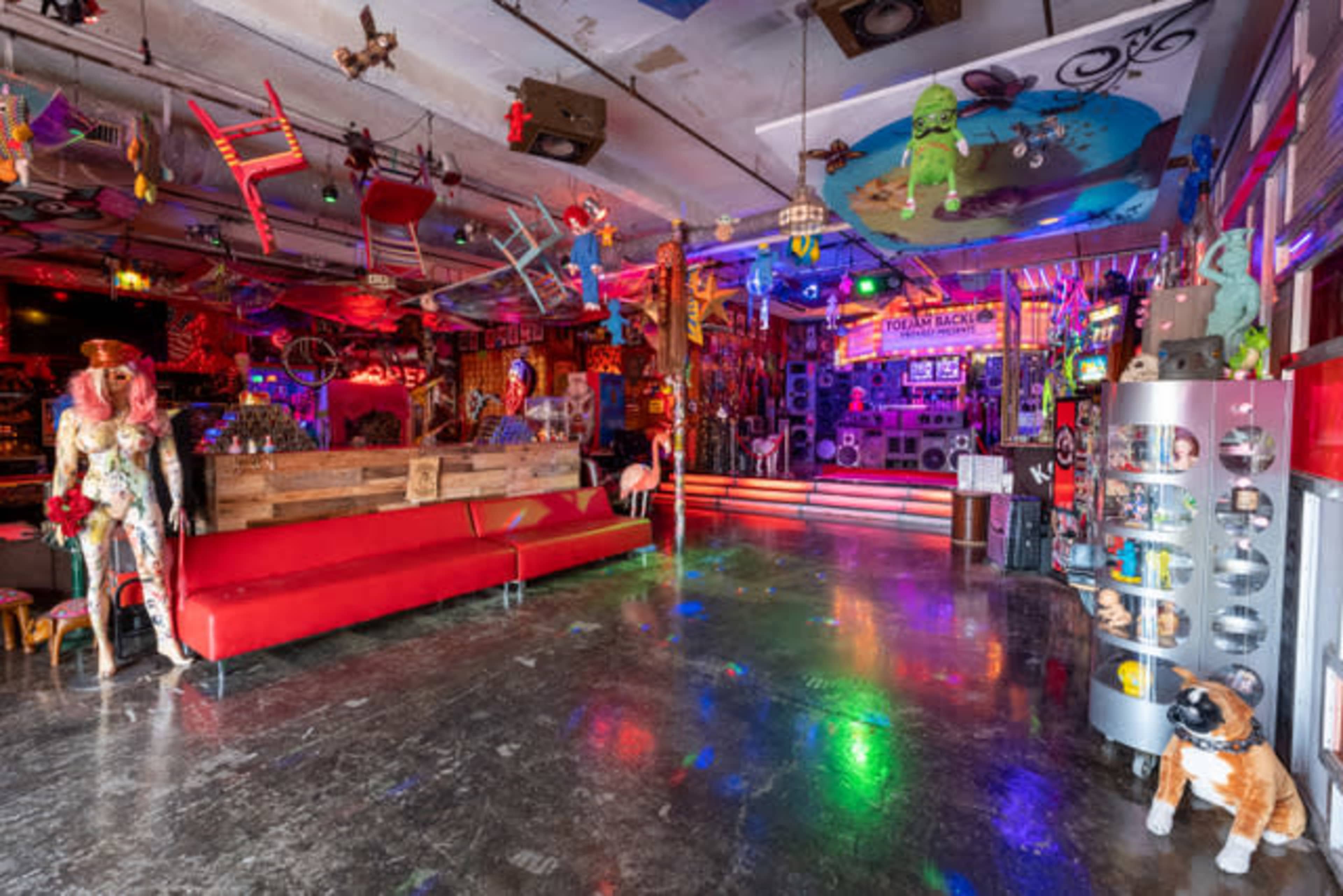 A vibrant, eclectic interior of a creatively decorated room filled with colorful furniture, art, and various playful elements.