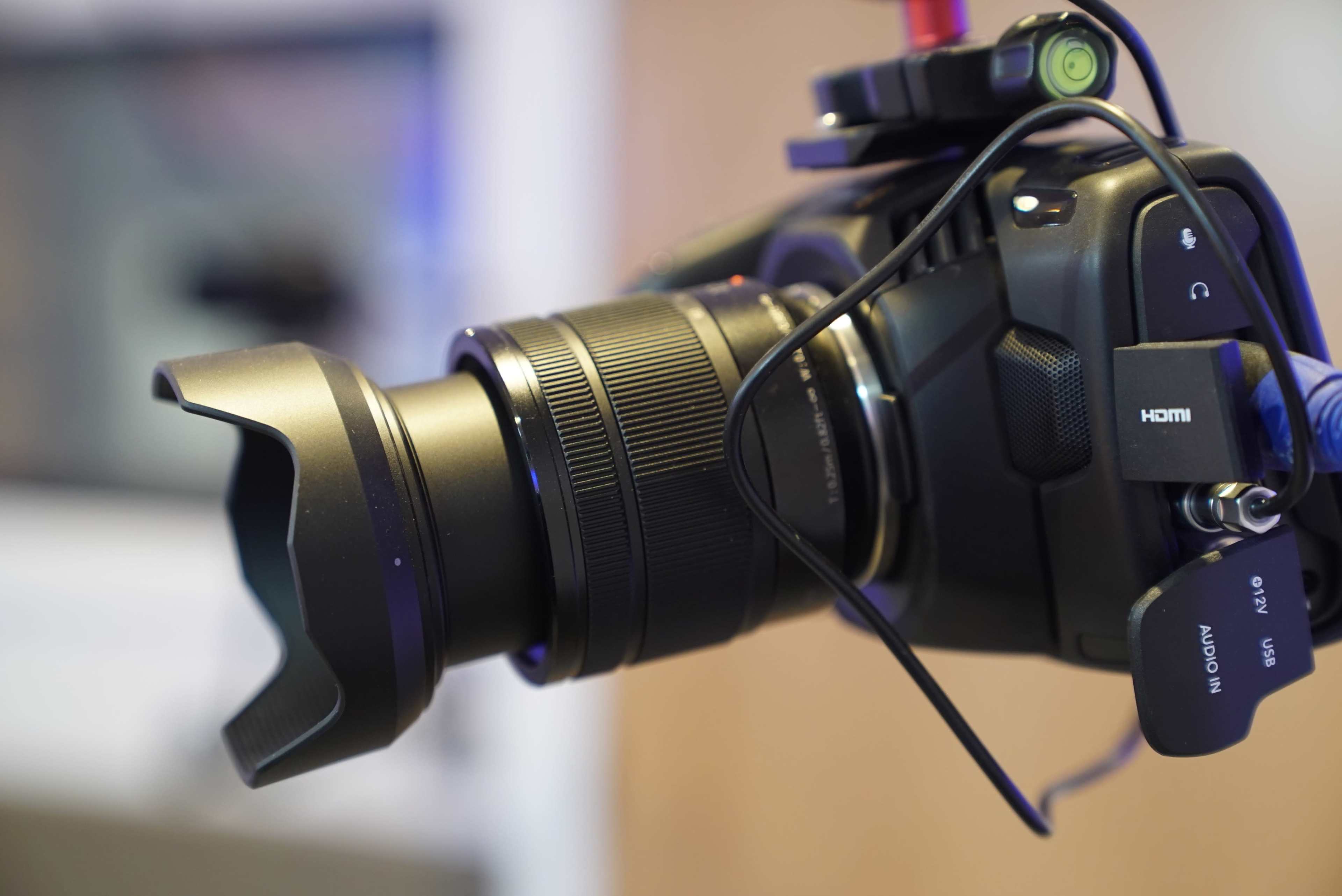A camera with a detachable lens and a lens hood attached.