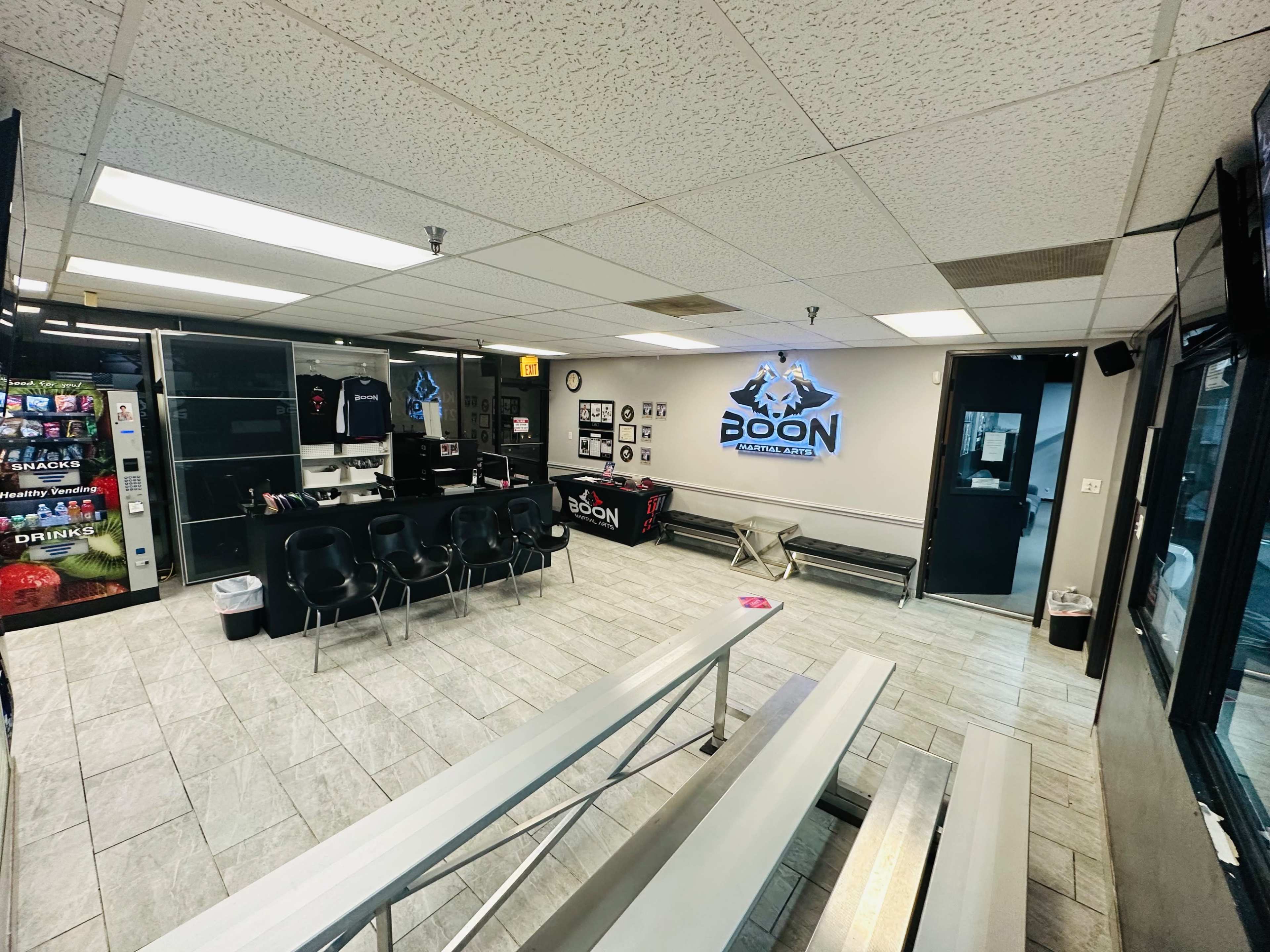 A spacious indoor area with seating, a counter displaying merchandise, and walls adorned with logos and framed pictures.