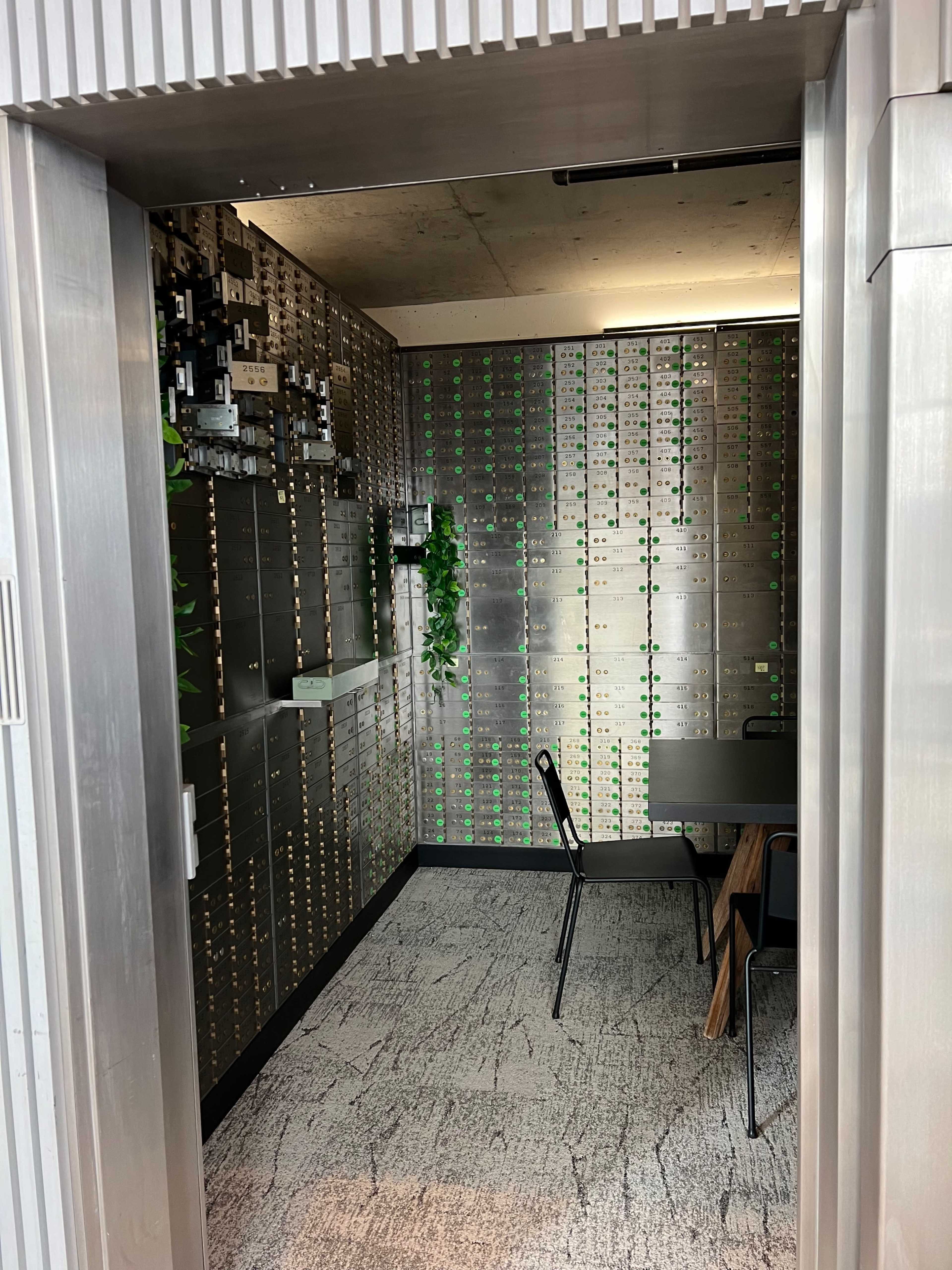 A modern room with metal wall panels, a table and chairs, and a decor of green plants.
