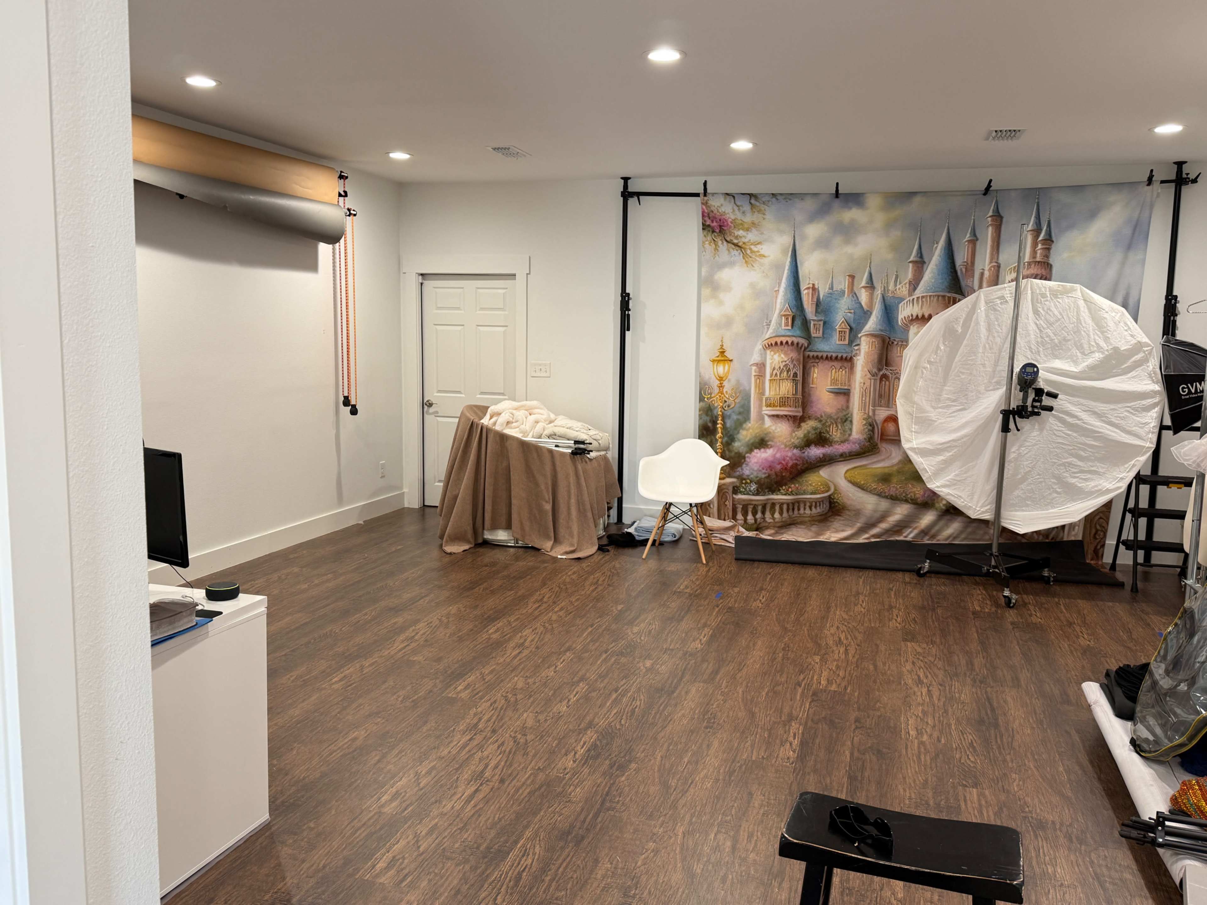 The room features hardwood flooring, a light-colored wall, and is furnished with a chair and a small table.