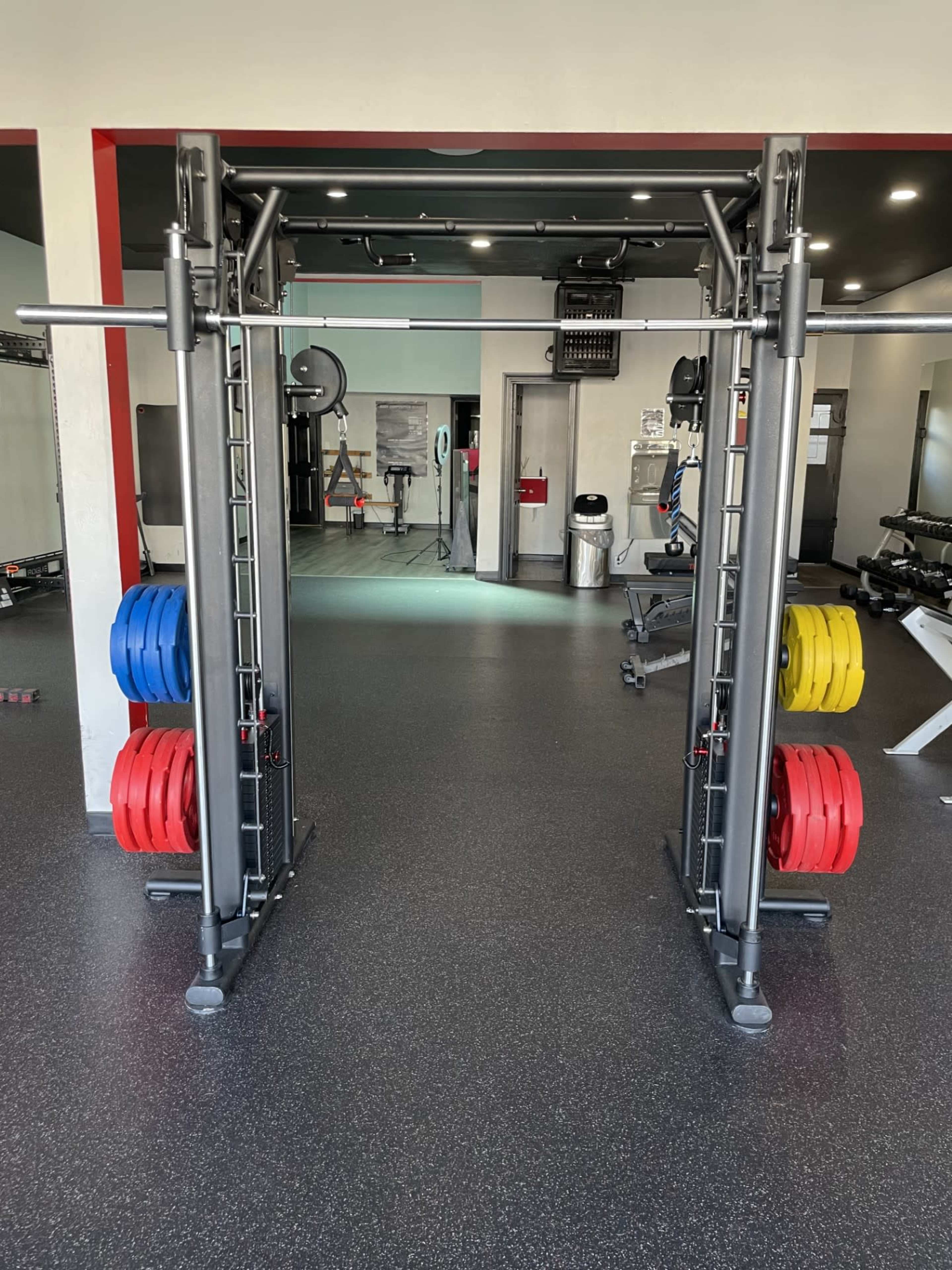 A power rack in a gym, equipped with various weight plates on both sides.