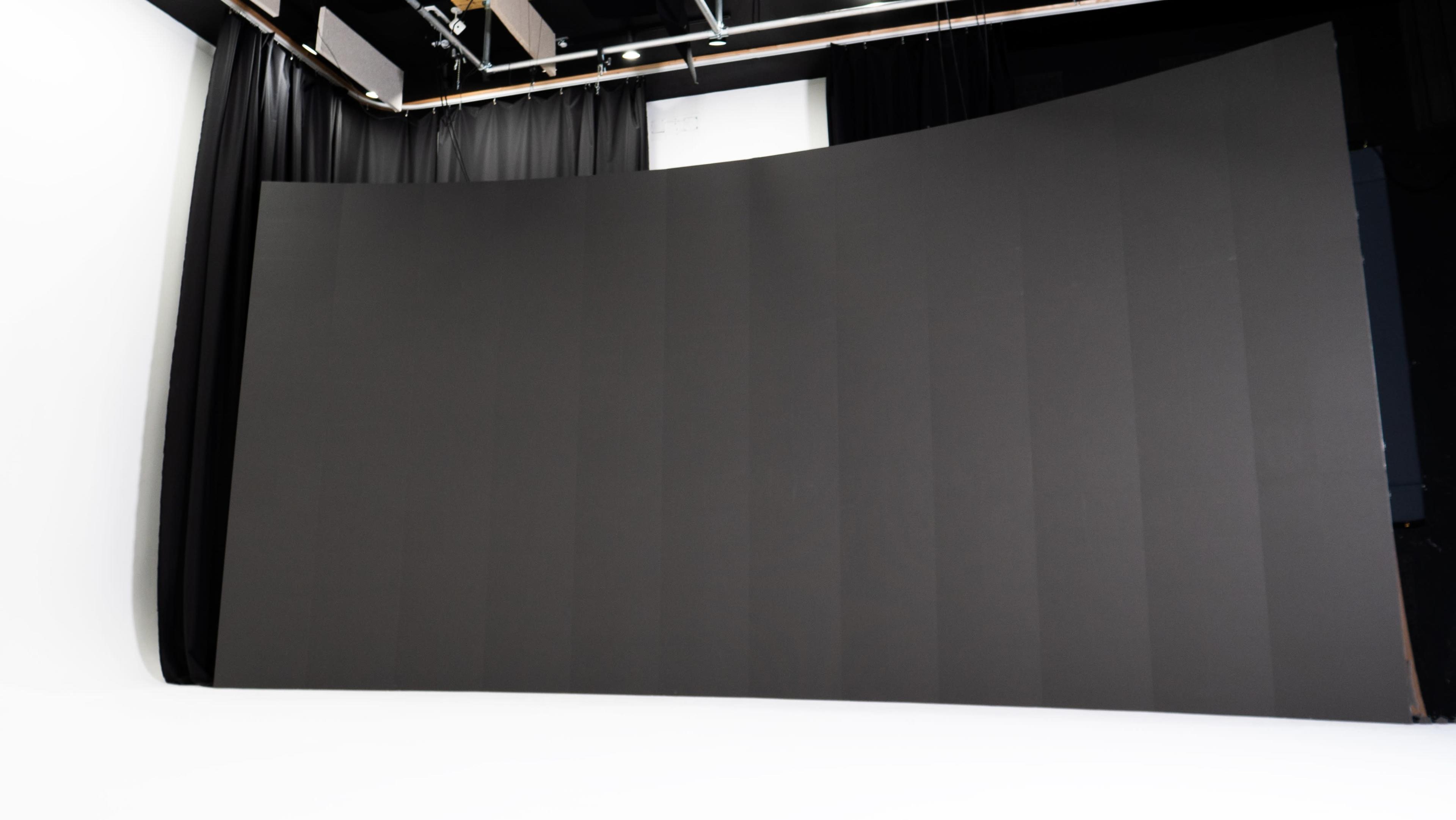 The image shows a large, curved black backdrop in a photography studio.