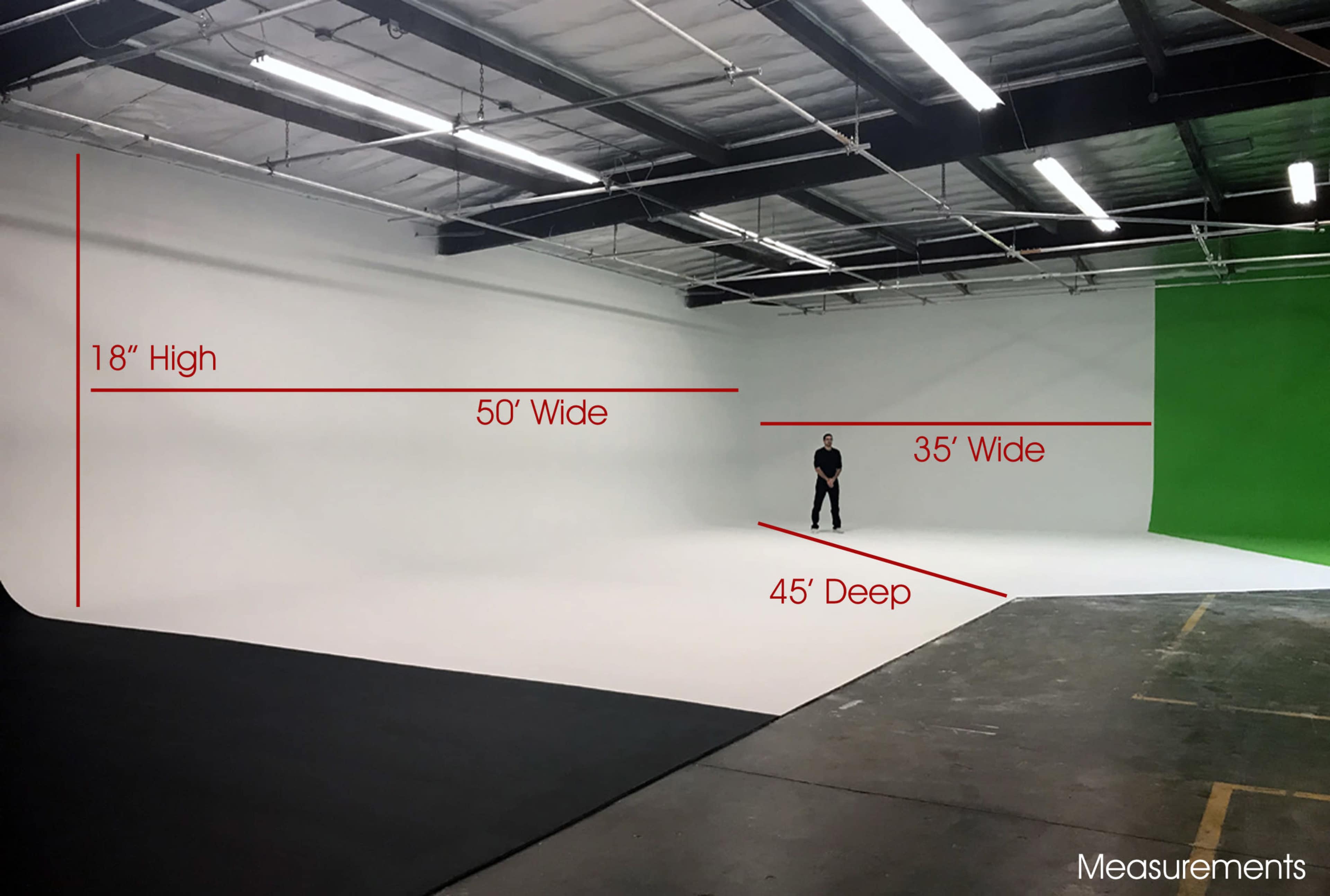 A large photography studio with a curved white backdrop, measuring 50 feet wide, 45 feet deep, and 18 inches high, alongside a green backdrop.
