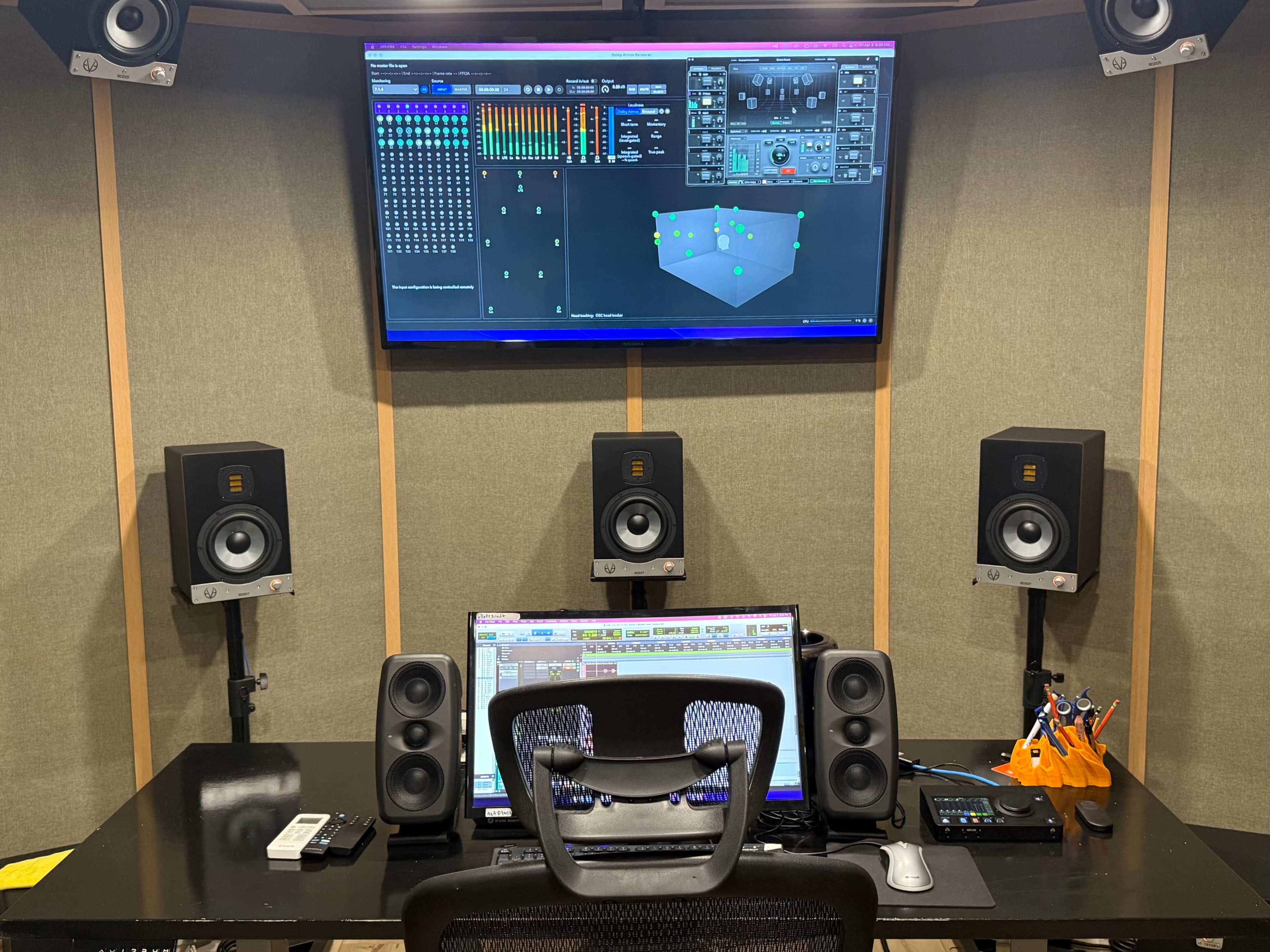 The image shows a sound recording studio with a computer screen displaying audio software and two studio monitors on either side.