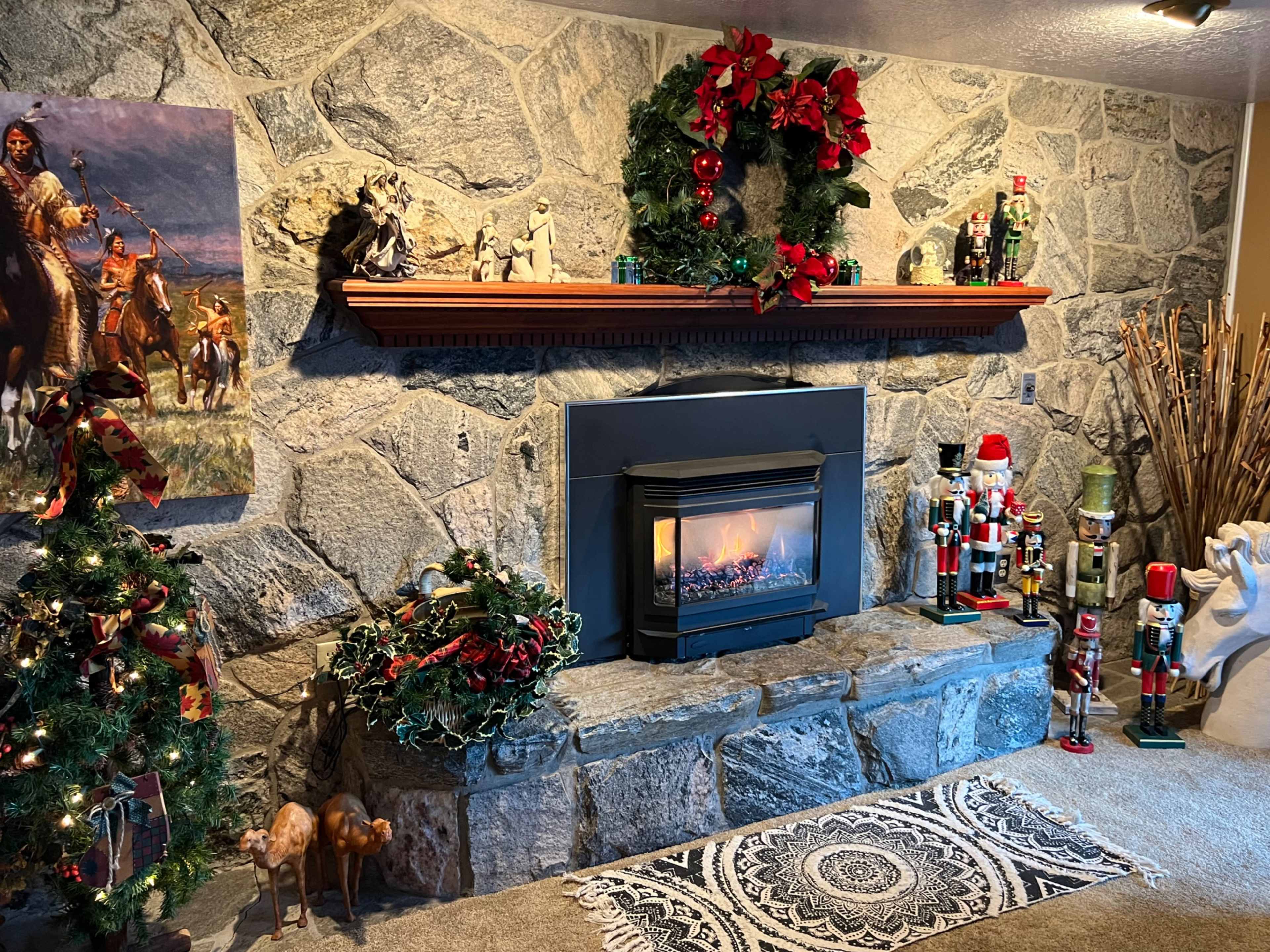 The scene features a decorated stone fireplace with a wooden mantel, surrounded by festive decorations including a Christmas tree, nutcracker figures, and a wreath.