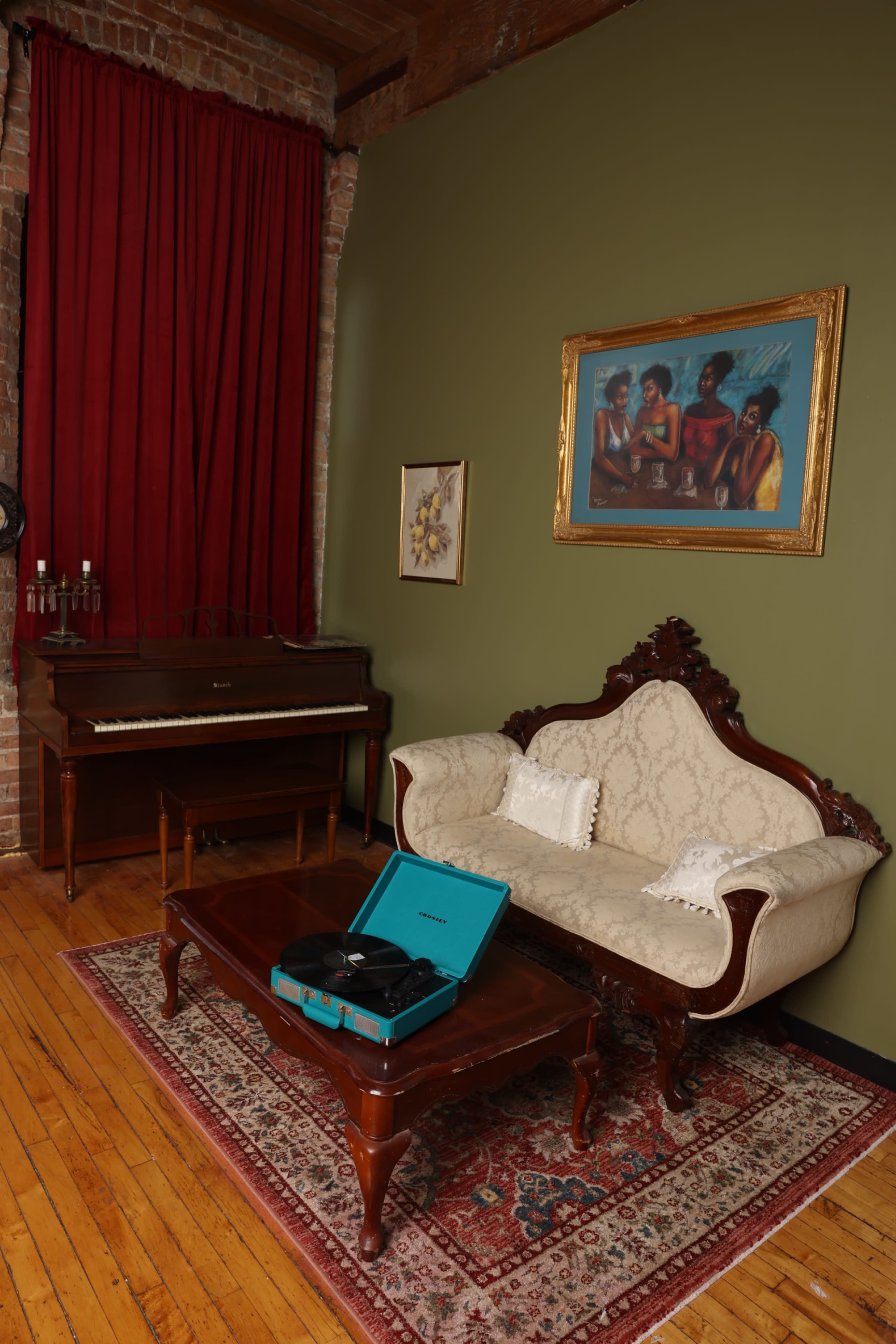 The scene features a vintage living room with a patterned rug, a wooden coffee table, an ornate sofa, and a piano, complemented by a red curtain and a framed painting on the wall.