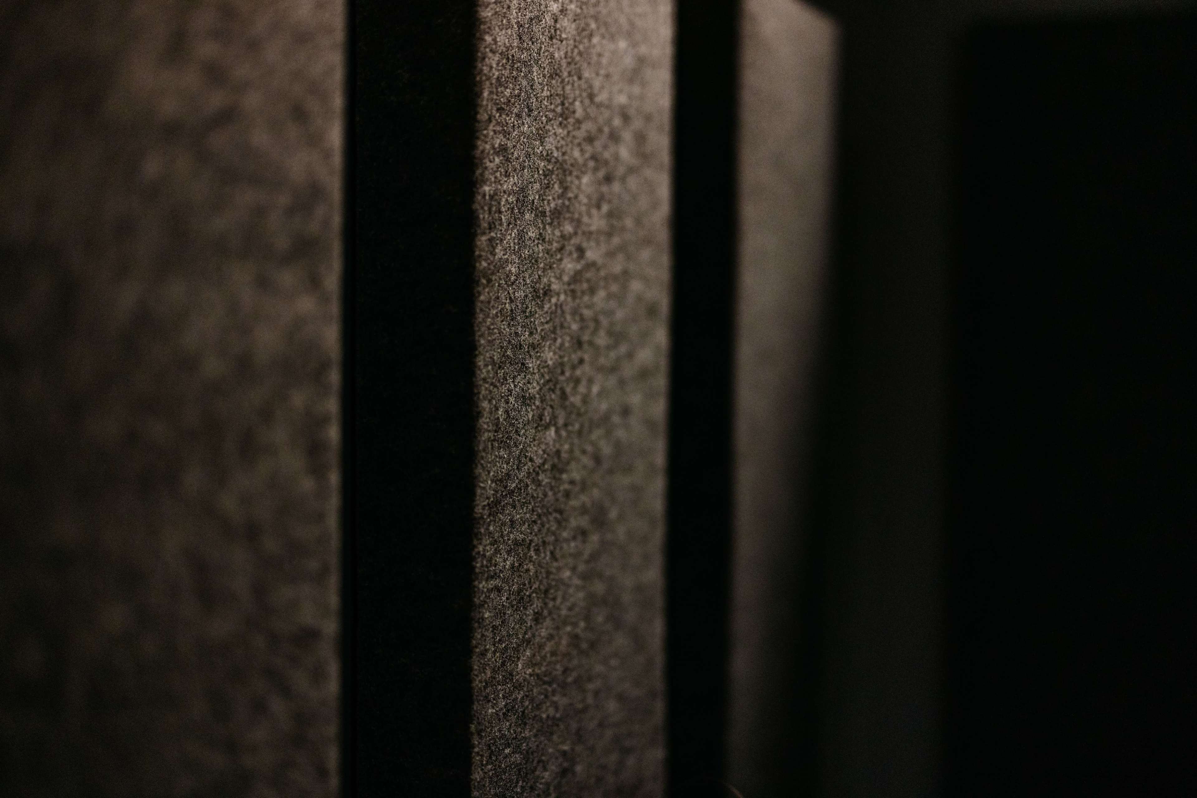 Textured, dark panels arranged vertically, with shadows highlighting their contours.