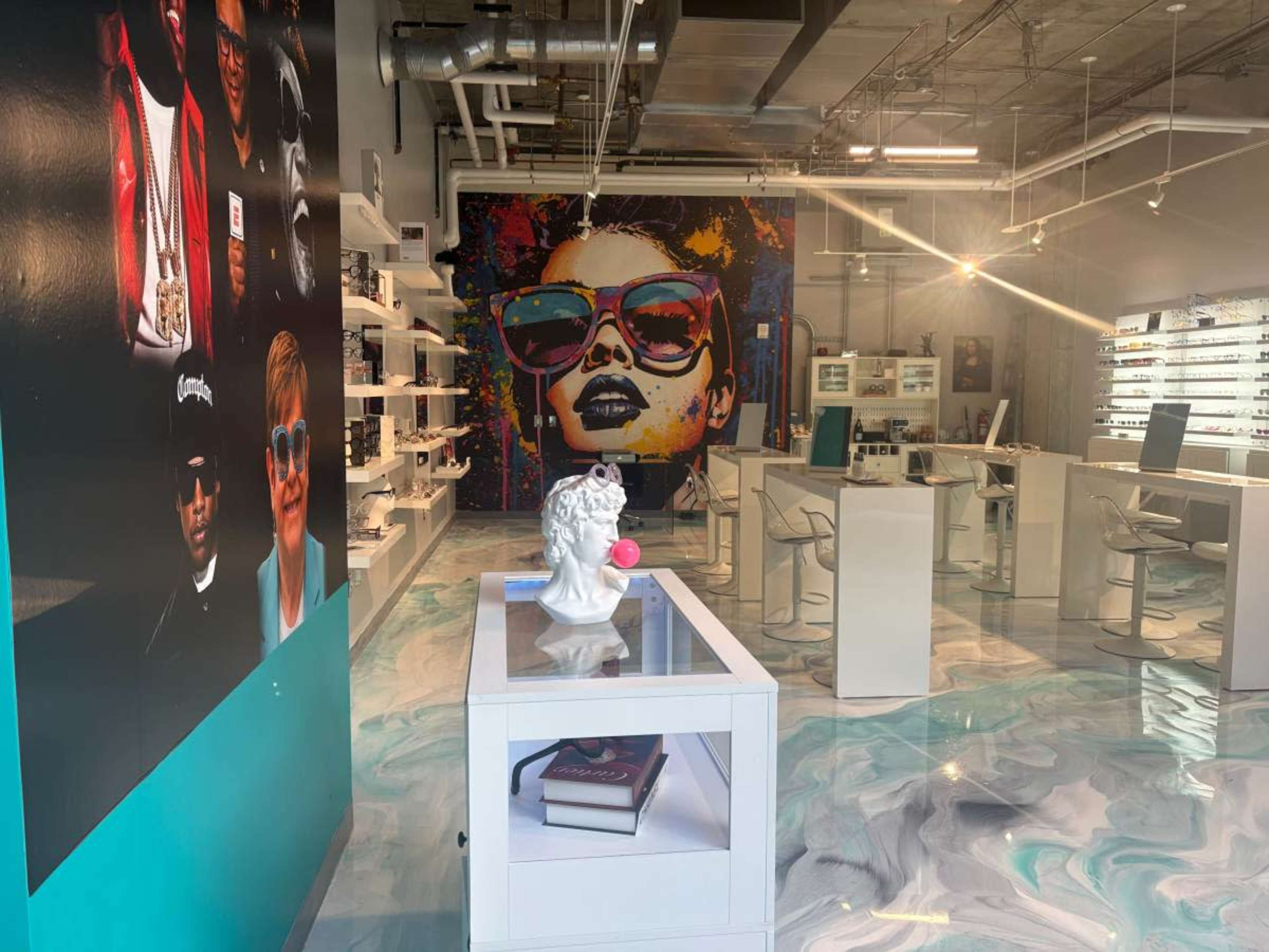 The interior of a modern eyewear store features vibrant murals, stylish displays, and a polished, multicolored floor.