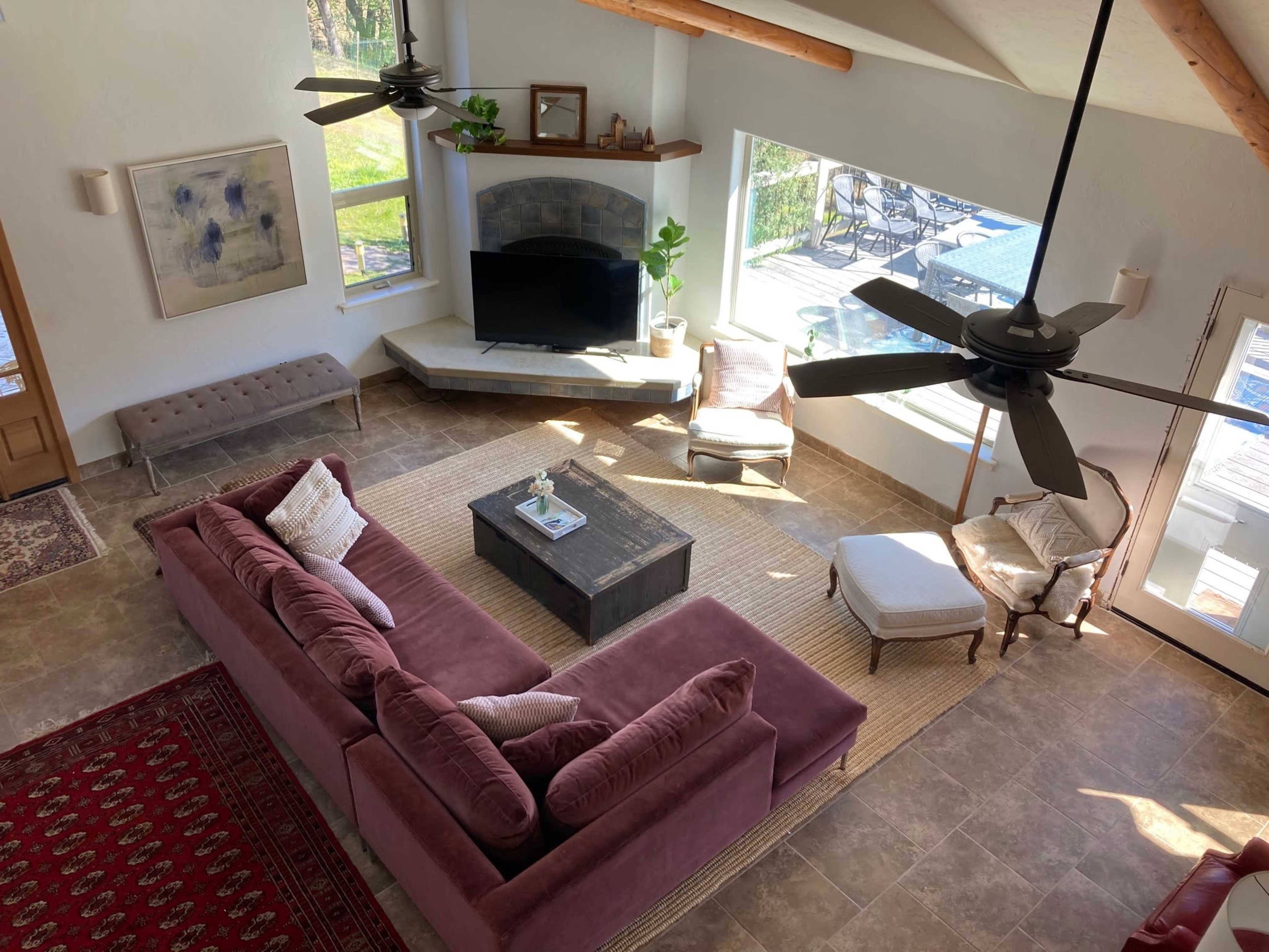 A spacious living room with a large sectional sofa, a coffee table, and a view of the outdoors through large windows.