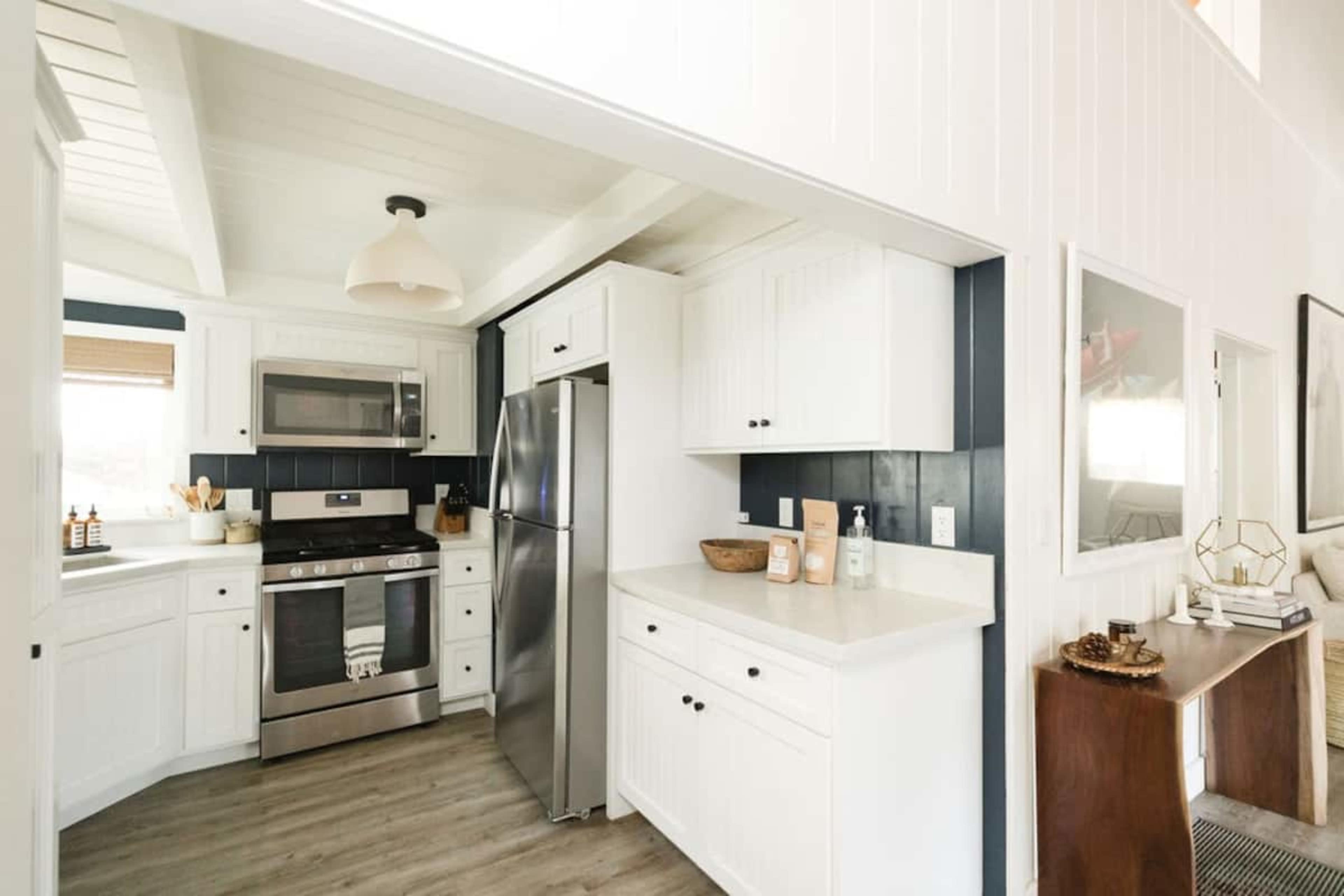 A modern kitchen featuring white cabinetry, stainless steel appliances, and a light-colored countertop.