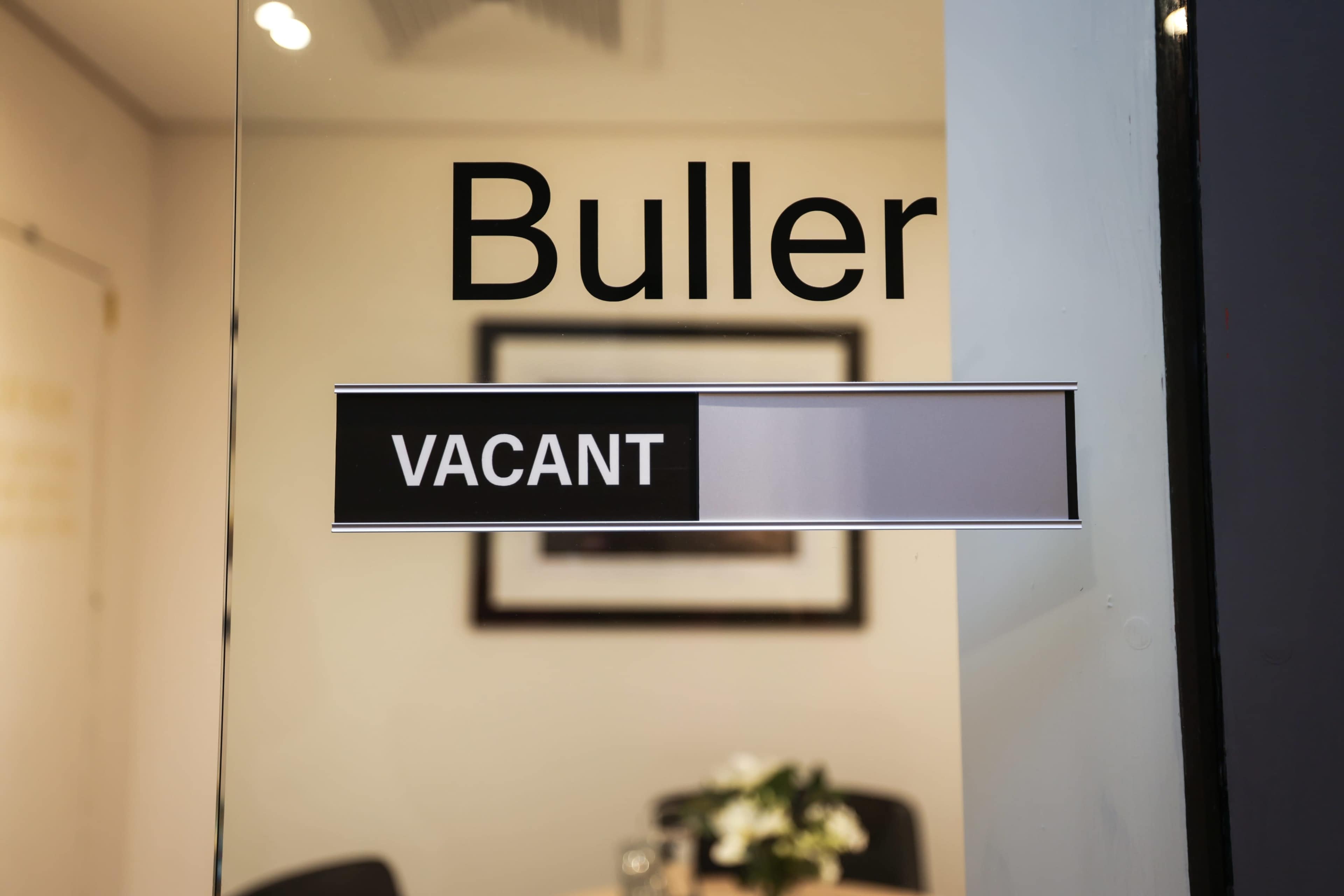 A glass door displays a sign reading "Buller" above a second sign that says "VACANT."