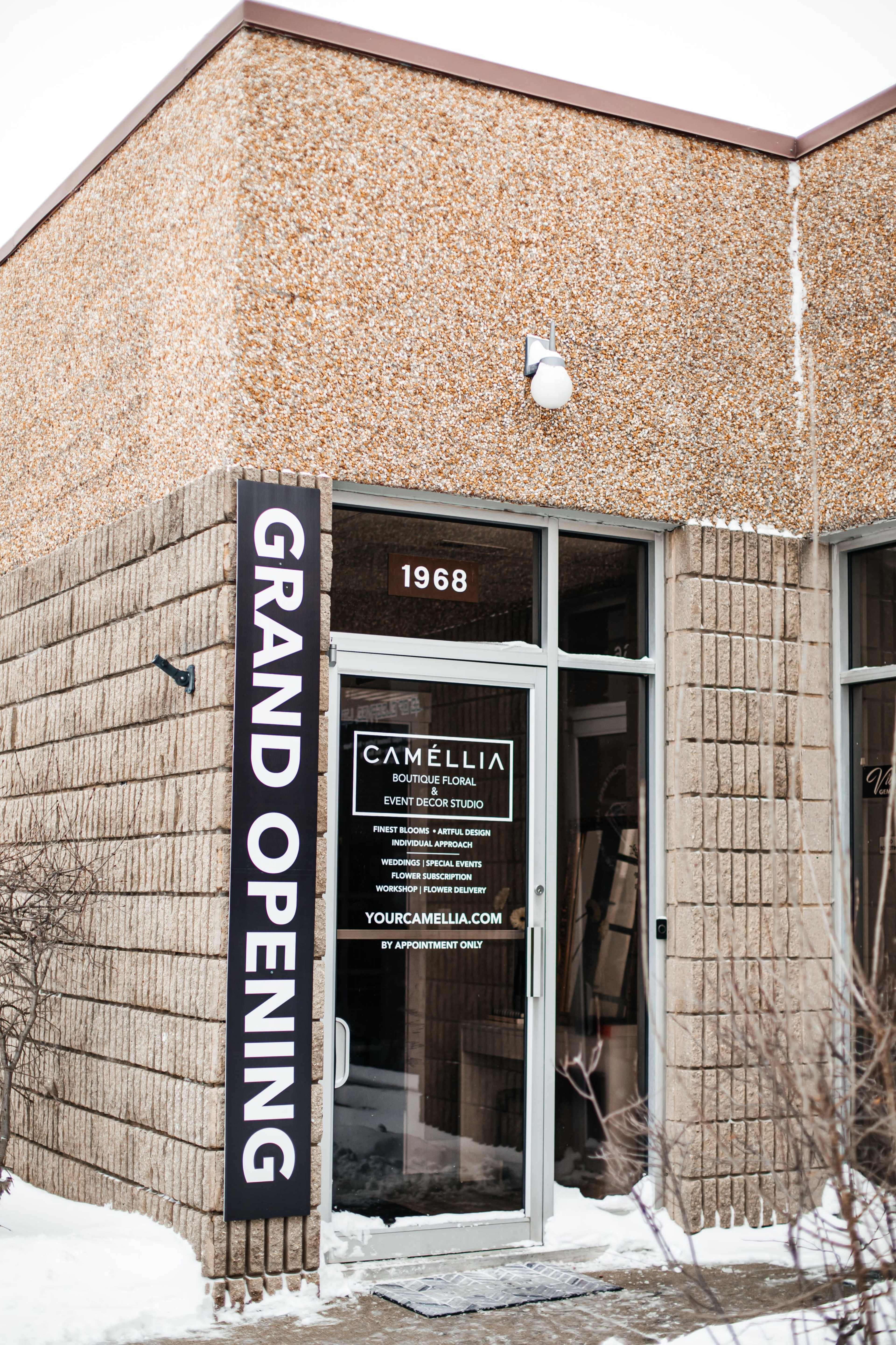 The image shows the entrance of a business called Camélia, featuring a "Grand Opening" sign, located at 1968.