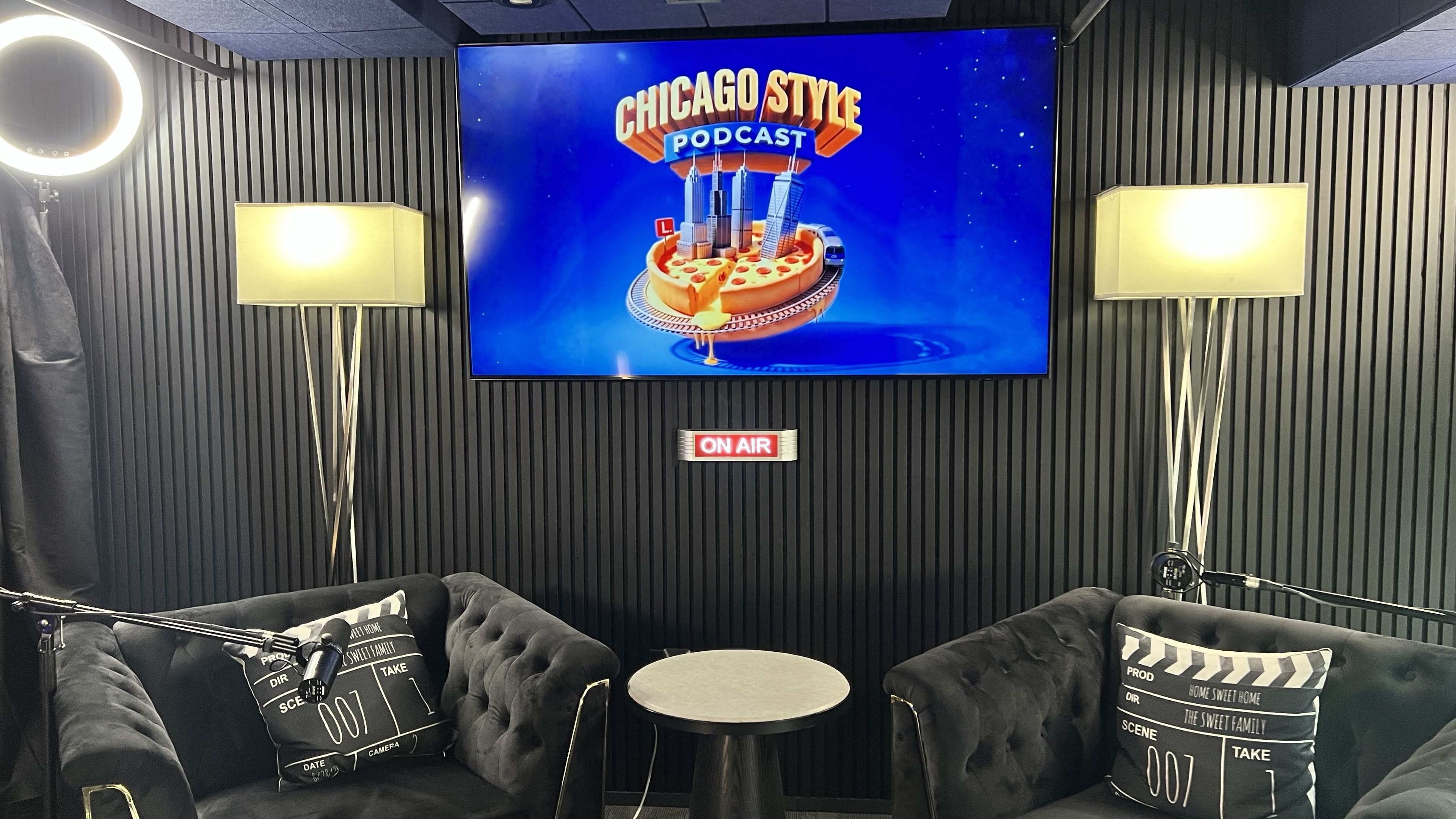 The image features a podcast studio with two black sofas, a small table, and a large screen displaying "Chicago Style Podcast" with a graphic of a pizza, along with studio lighting.
