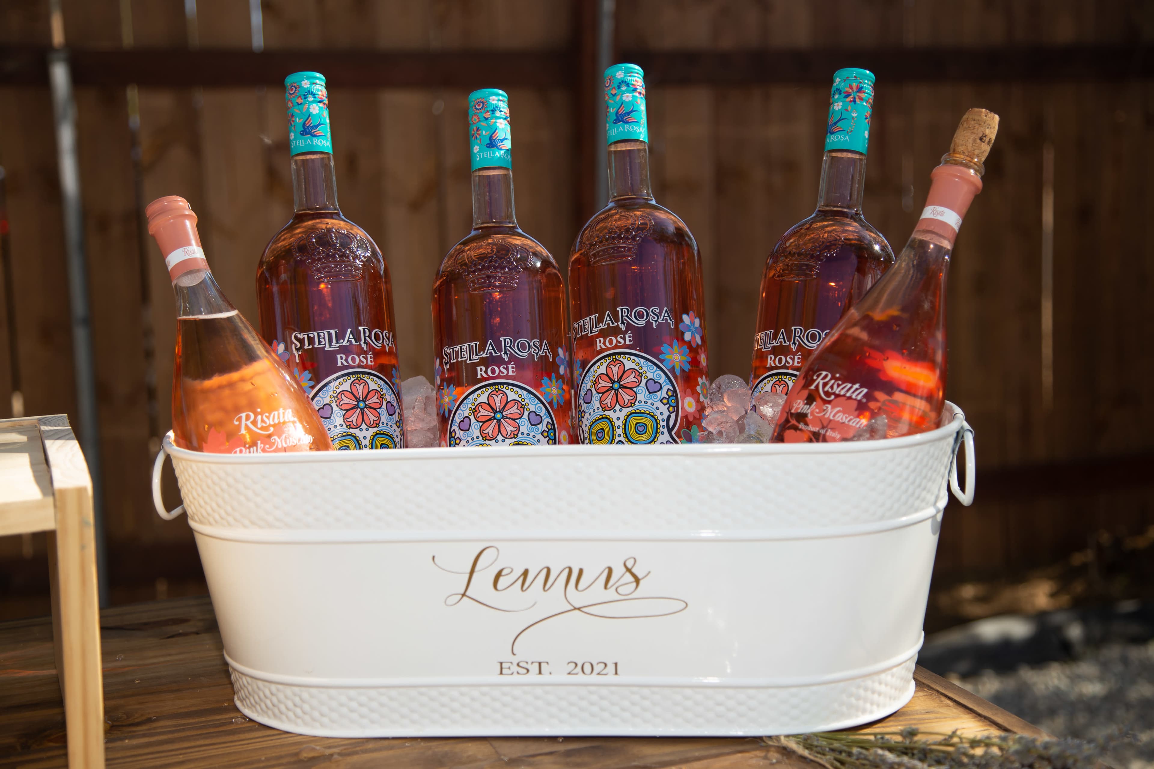 A white metal tub filled with ice holds several bottles of Stella Rosa Rosé wine.