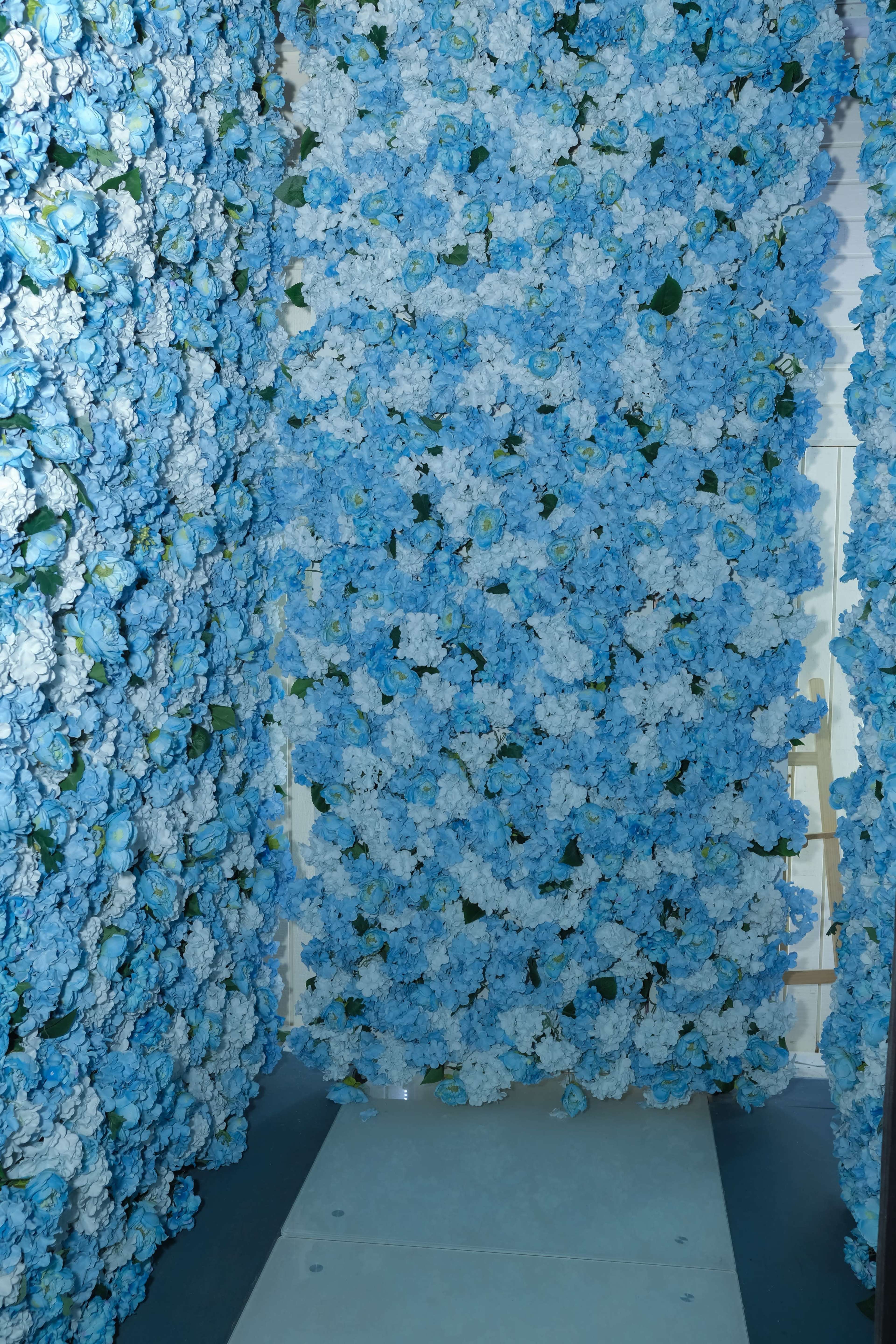 A corridor lined with blue and white artificial flowers on either side.
