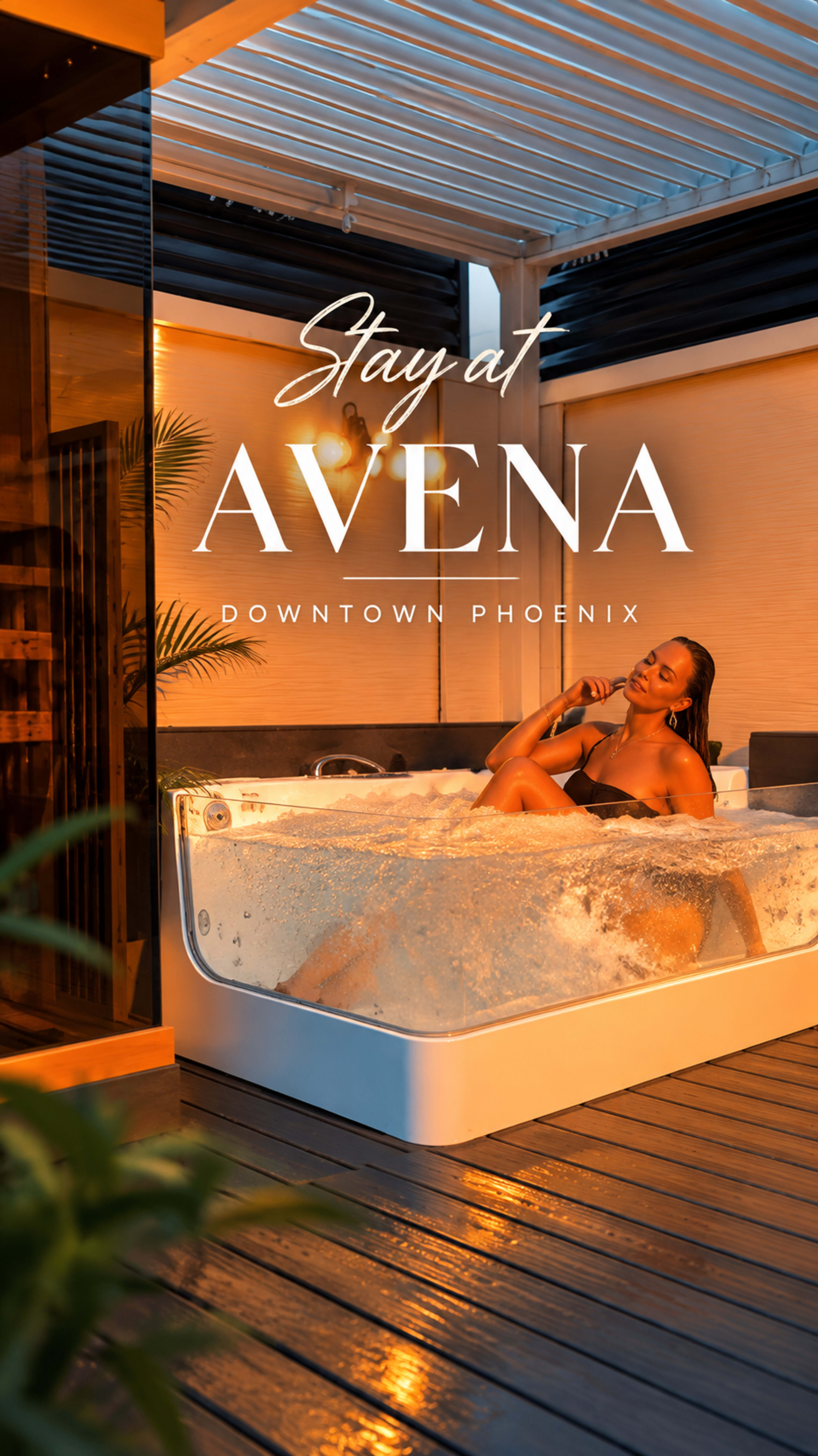 A woman relaxes in a hot tub on a deck surrounded by modern architecture and tropical plants in downtown Phoenix.