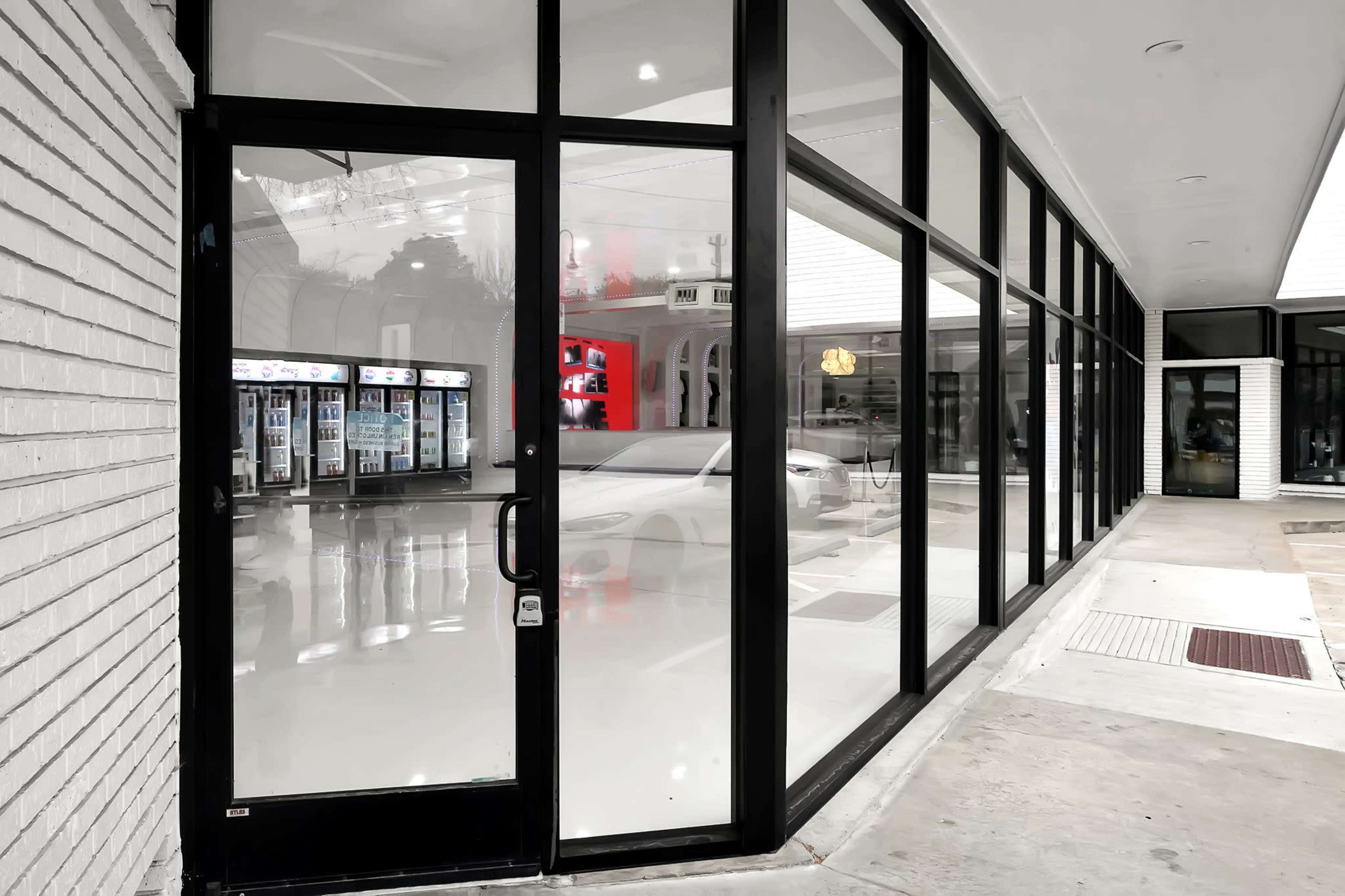 A modern storefront with large glass windows and a polished floor, featuring vending machines visible inside.