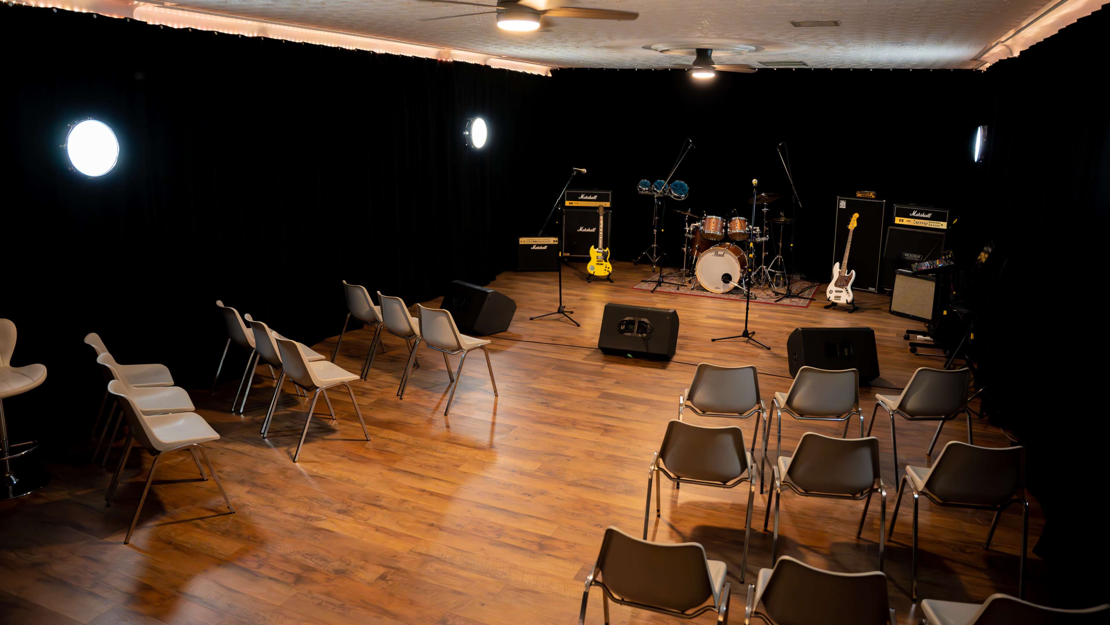 A small stage is set up for a performance, surrounded by empty chairs arranged in rows.
