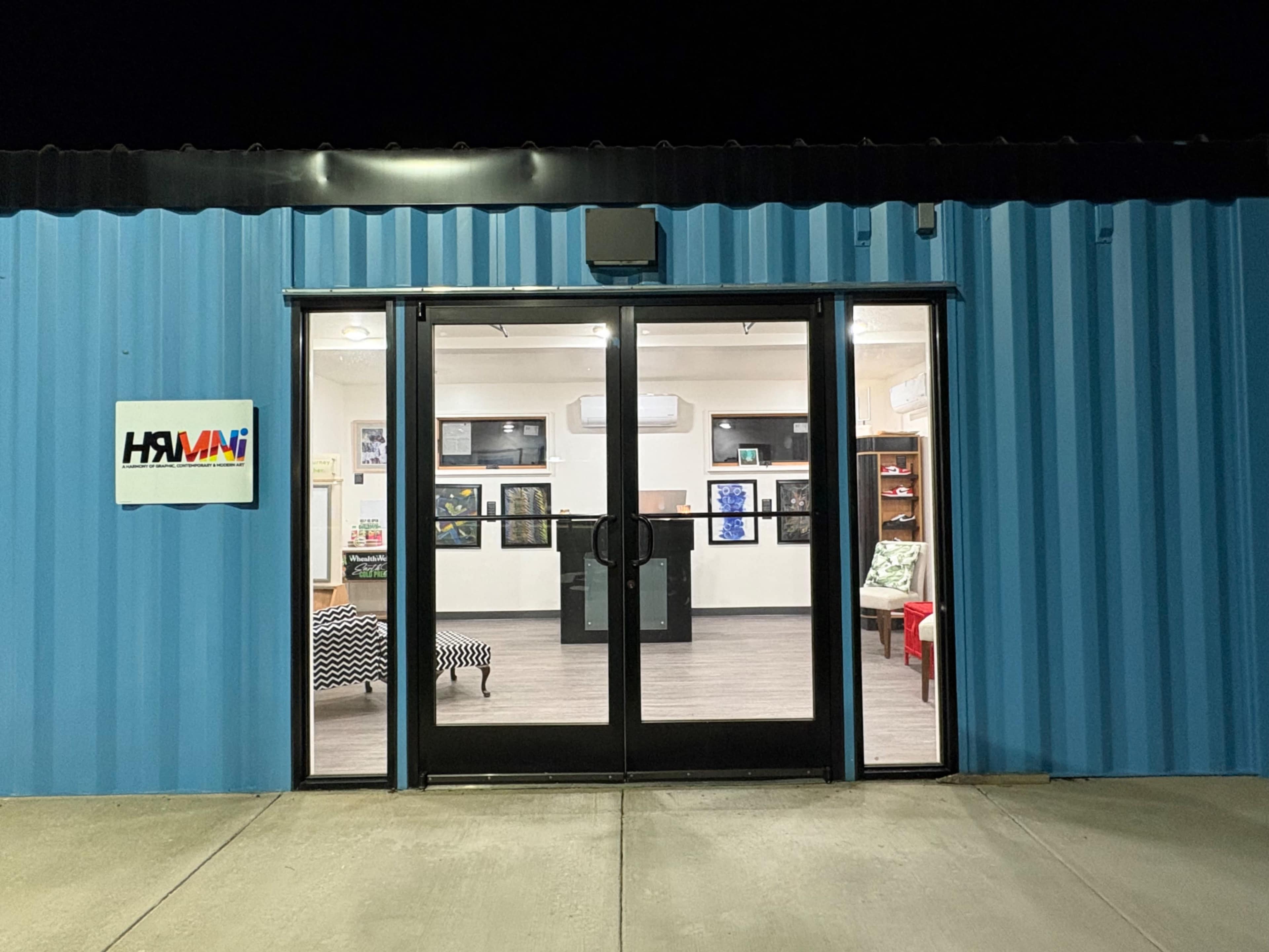 The image shows a brightly lit storefront with glass double doors, featuring a blue corrugated metal exterior and a sign labeled "HAVANI."