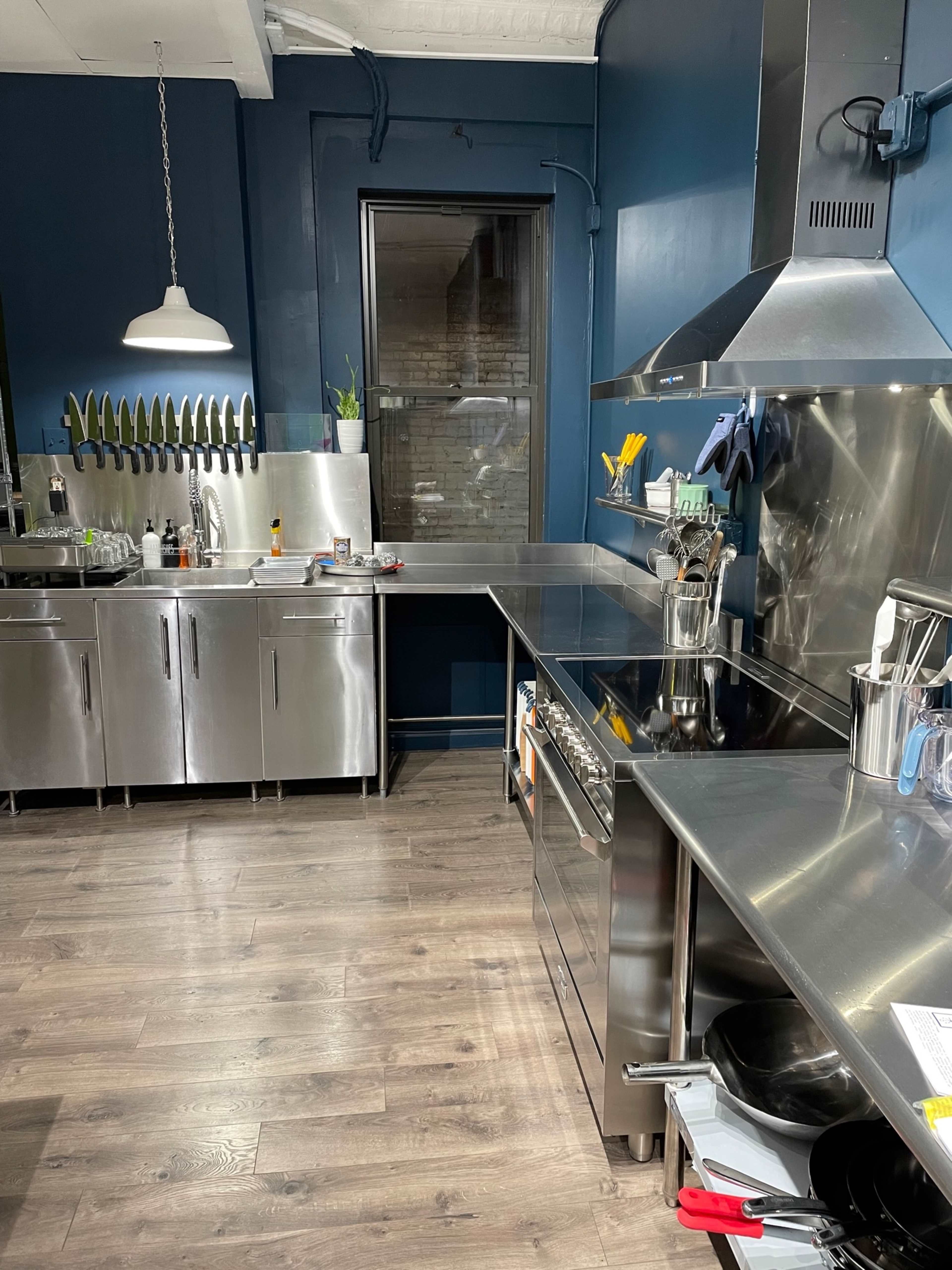 A modern kitchen with stainless steel appliances, a large countertop, and a wall-mounted knife rack.