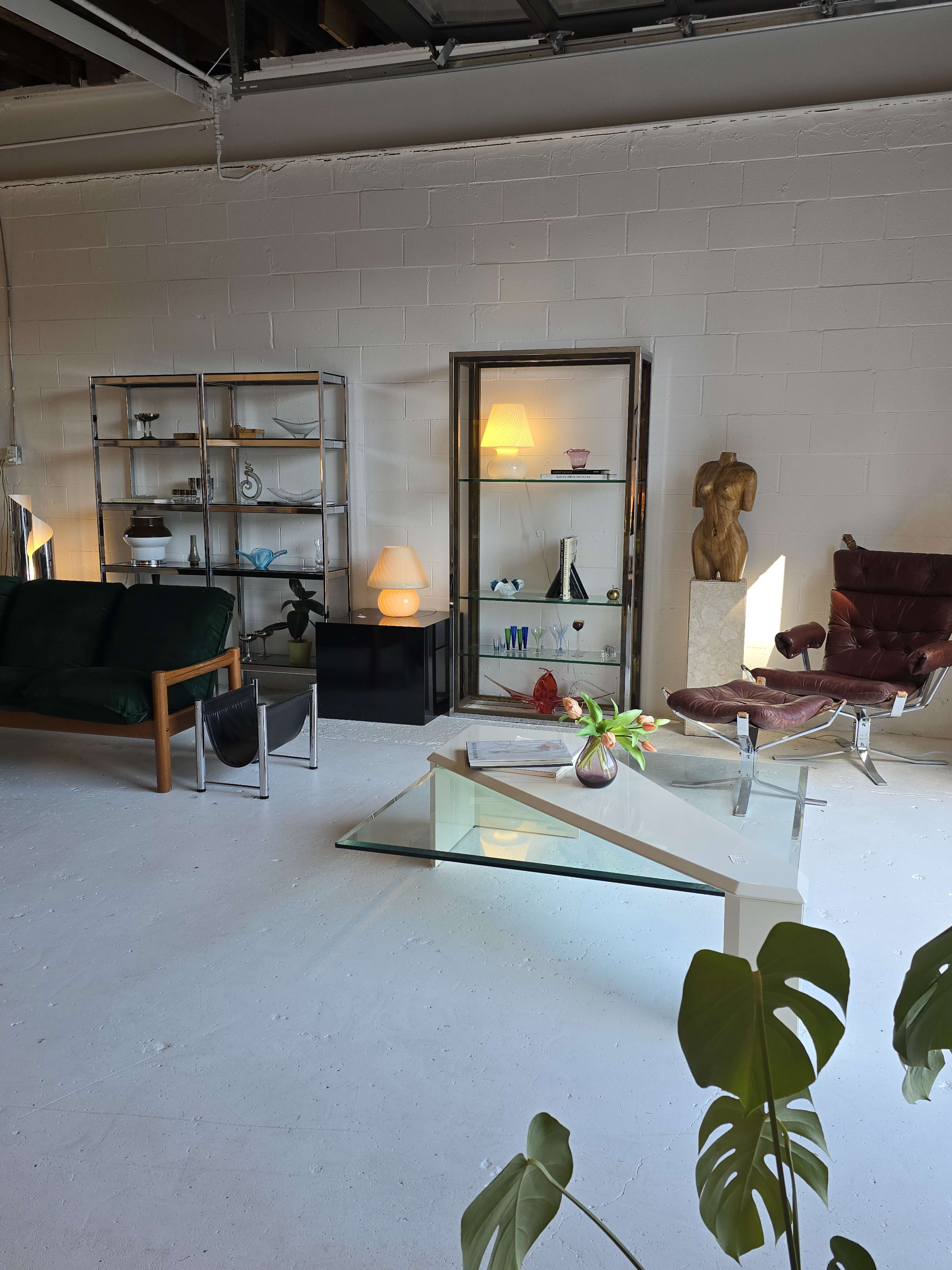 The scene features a modern interior with various furniture pieces, including sofas, a glass coffee table, and a display cabinet, arranged in a well-lit space.