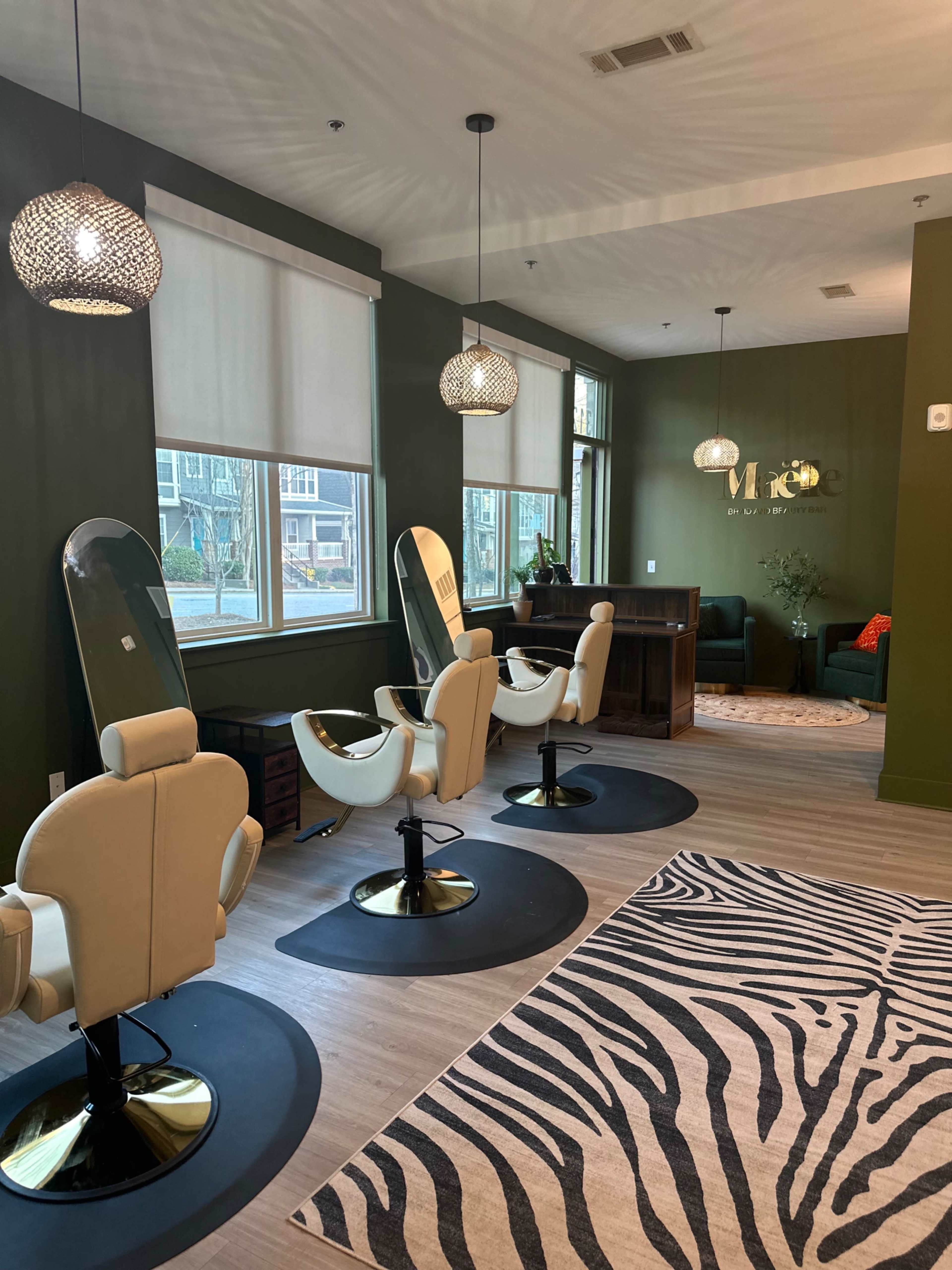 The image shows a modern hair salon with three styling chairs, a reception area, and a decorative zebra print rug on the floor.