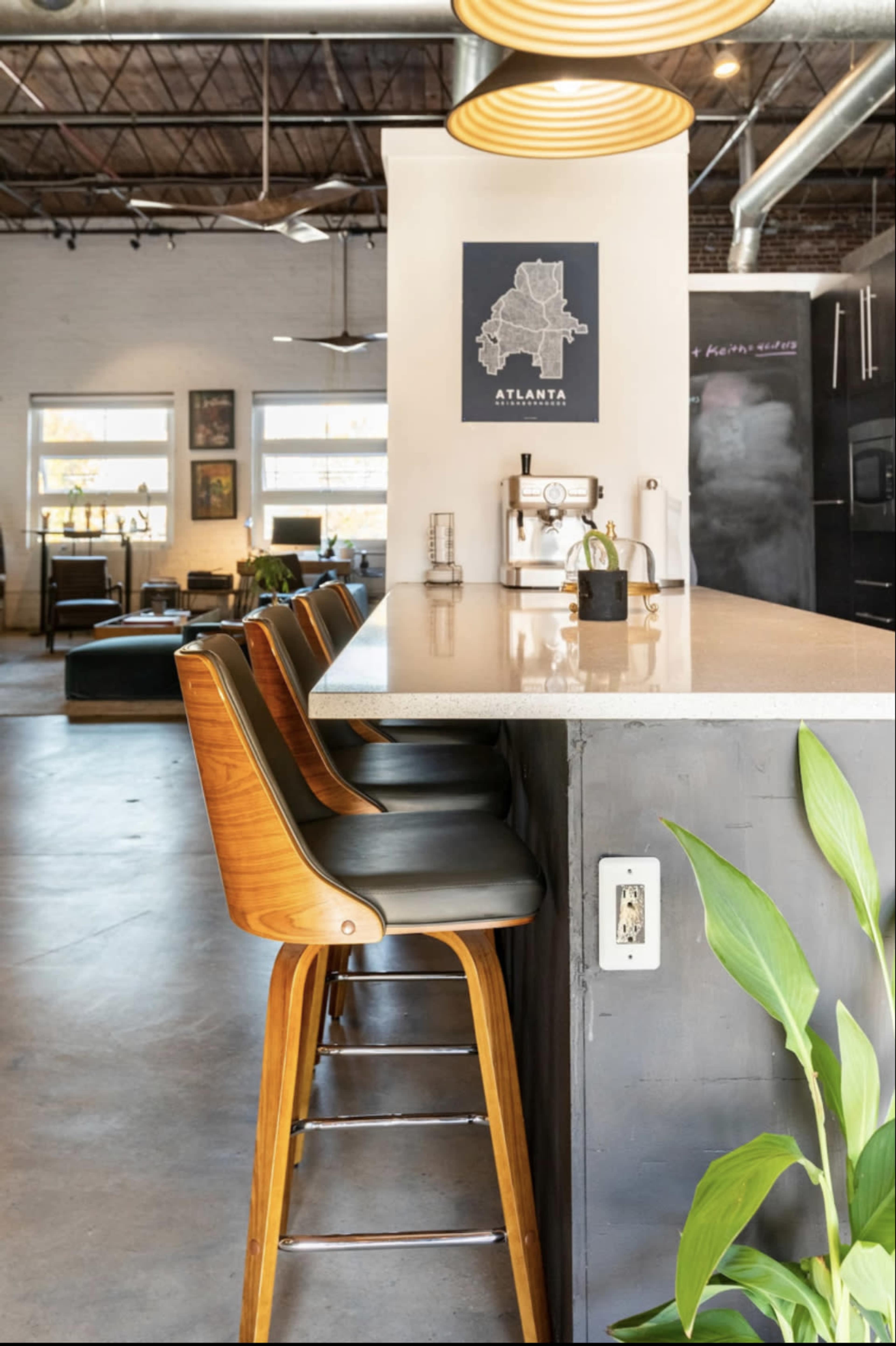 A modern kitchen bar with wooden stools, a countertop, and a wall-mounted map of Atlanta.