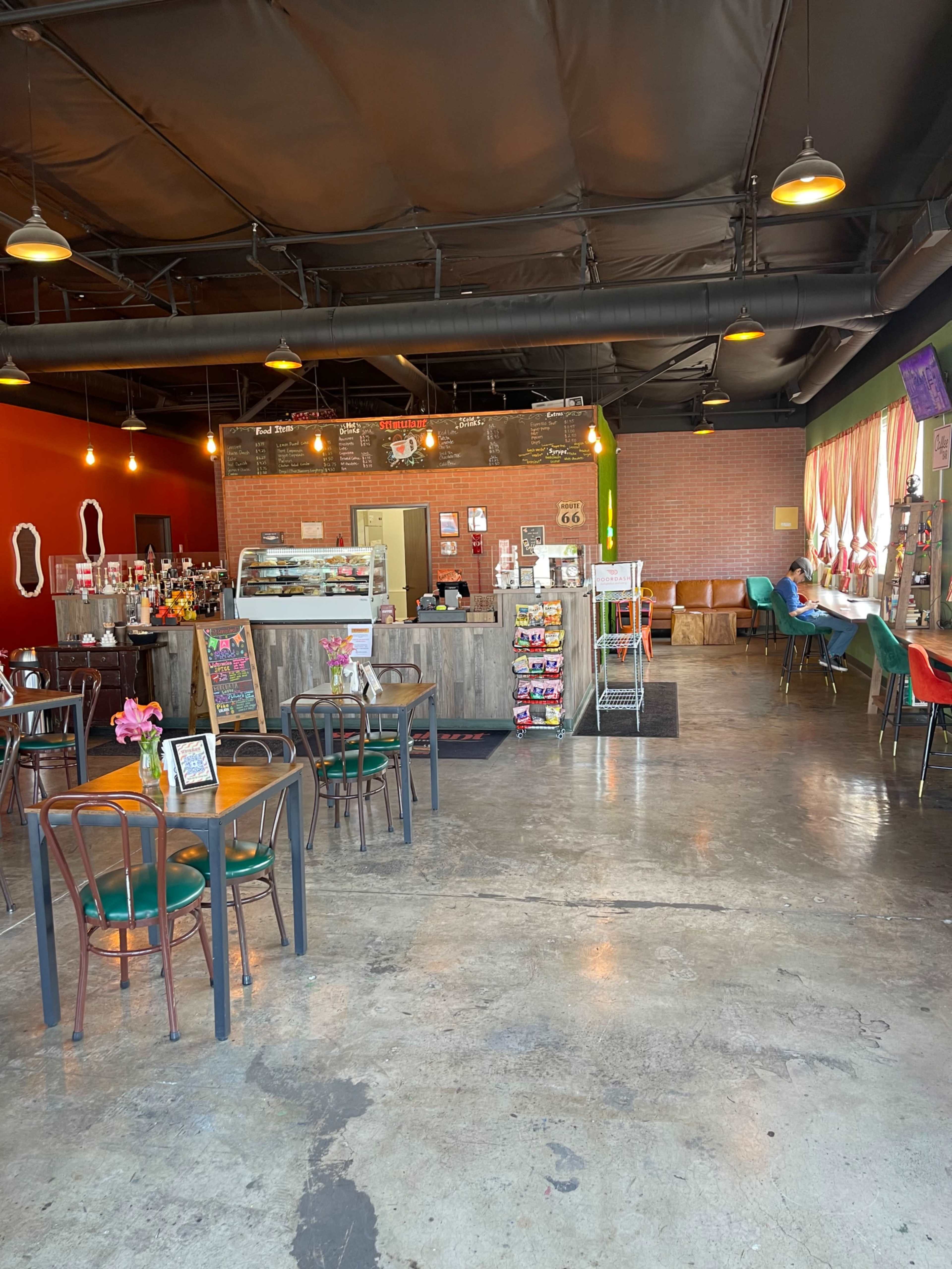A café interior with seating arrangements, a service counter, and decorative elements on the walls.