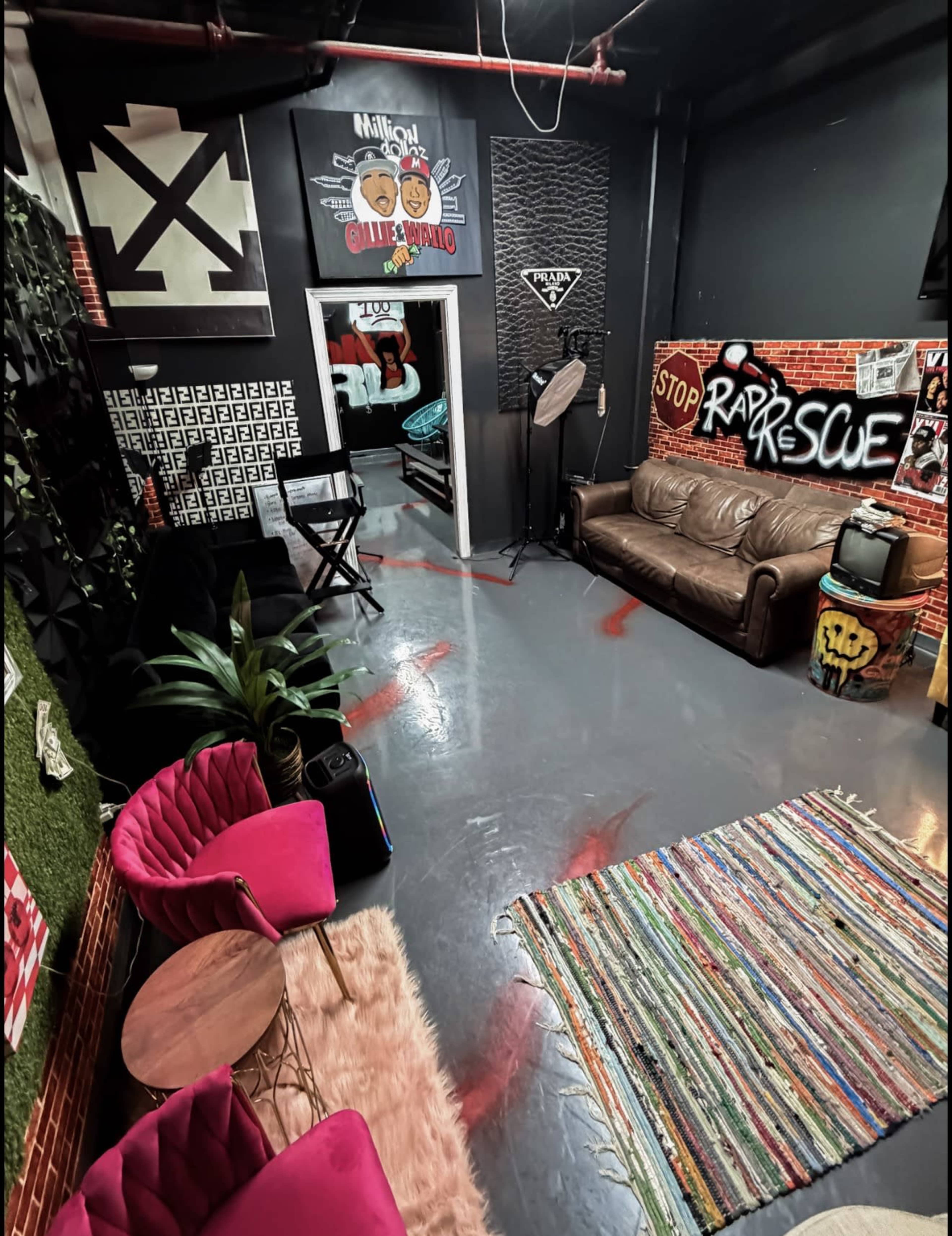The image shows a creative workspace featuring a sectional sofa, colorful chairs, a rug, and graffiti art on the walls.