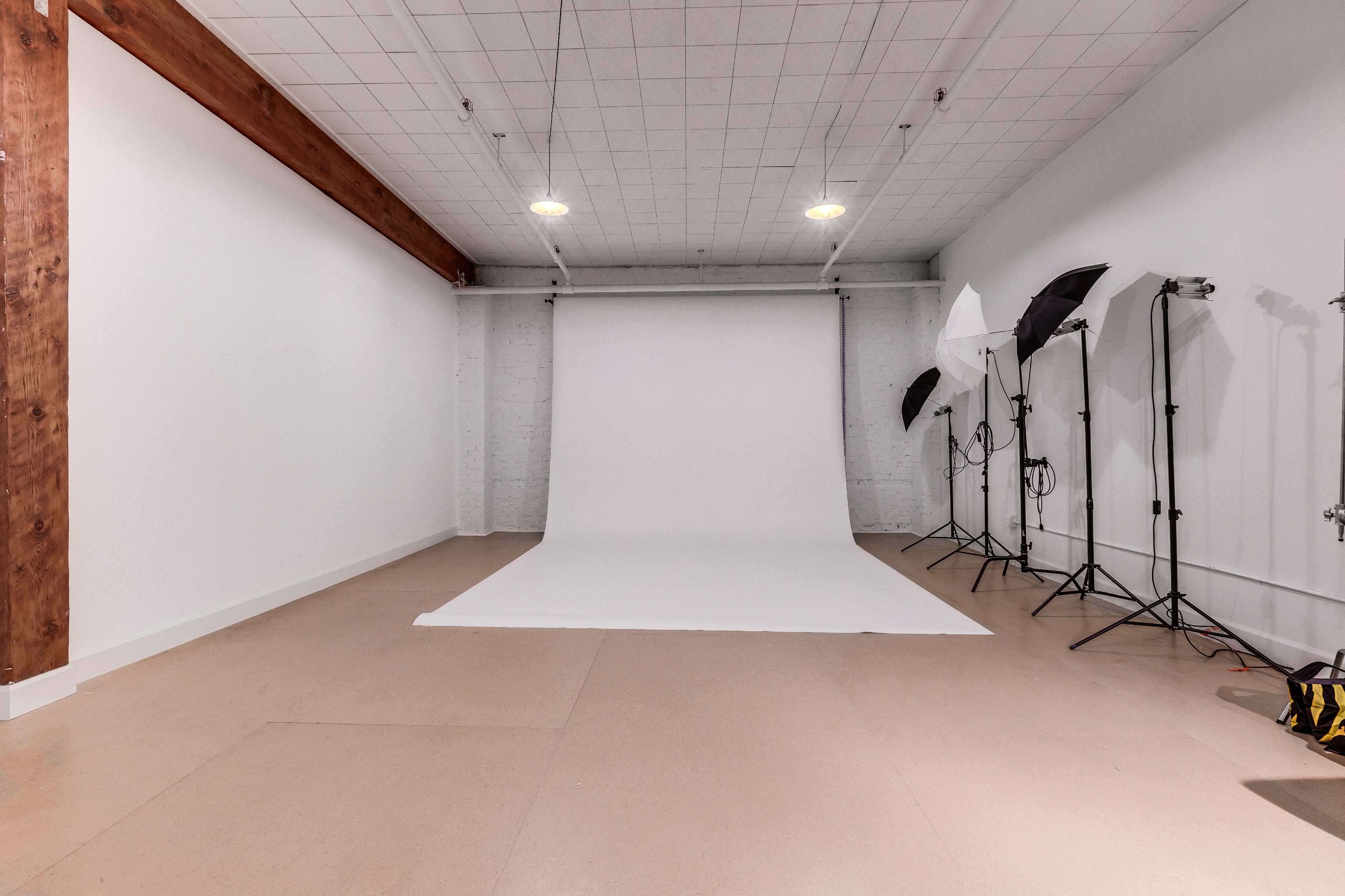 A photography studio featuring a white backdrop, softbox lights, and a clean, minimalist interior.